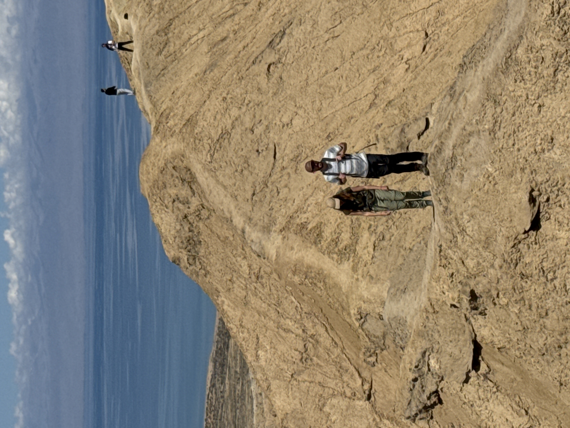 Hikers traverse rocky cliffs near Tong, Kyrgyzstan
