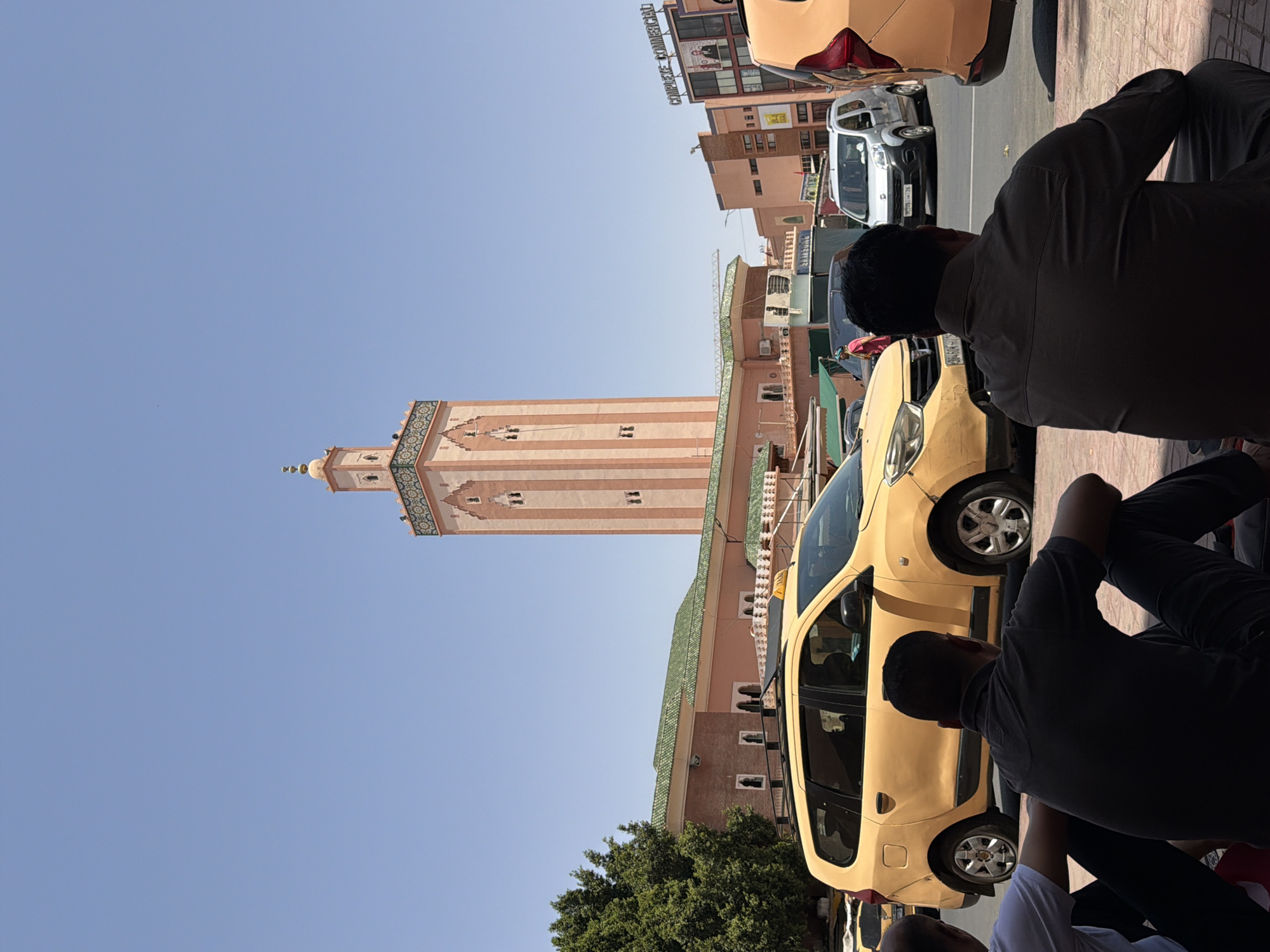 Tourist photographs iconic Koutoubia Mosque minaret in Marrakesh