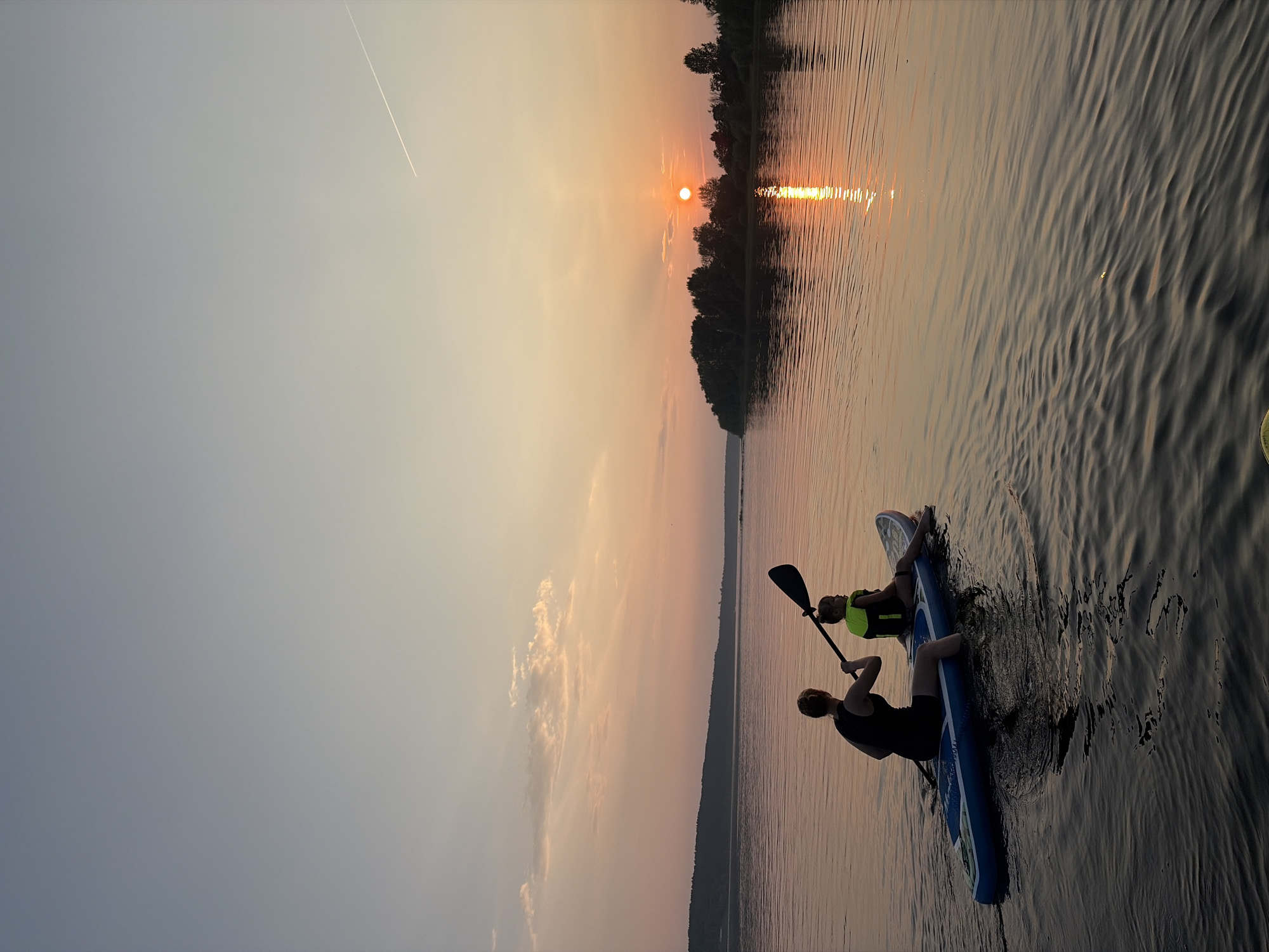 Sunset paddleboarding on calm Russian waters, summer evening