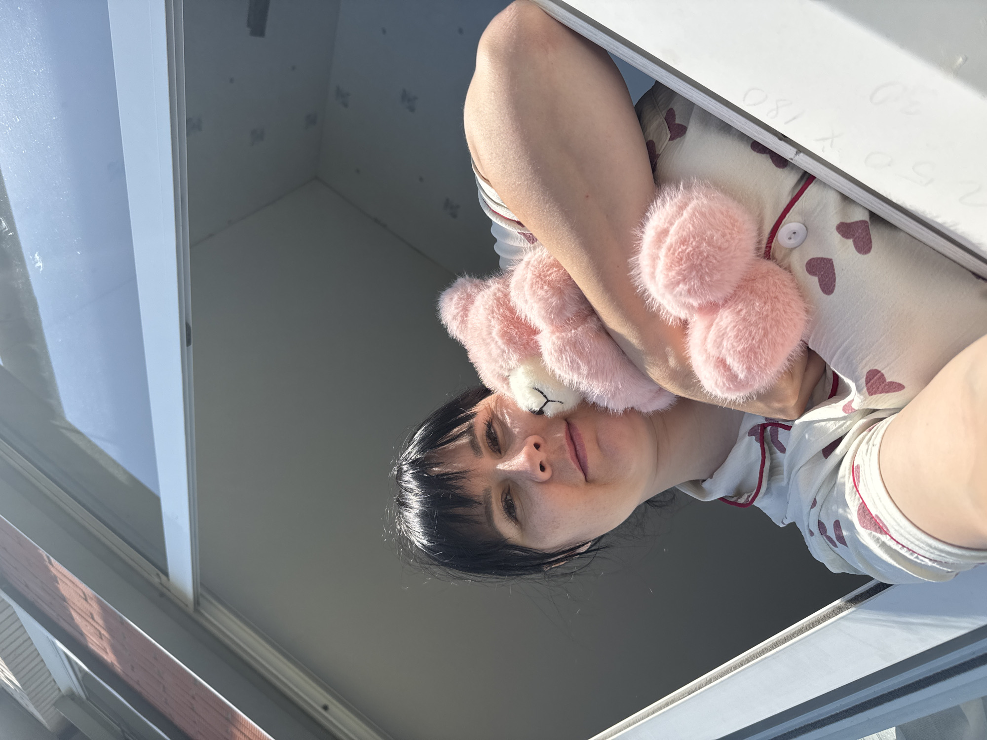 Woman with pink teddy bear spotted at window in Zav'yalovo