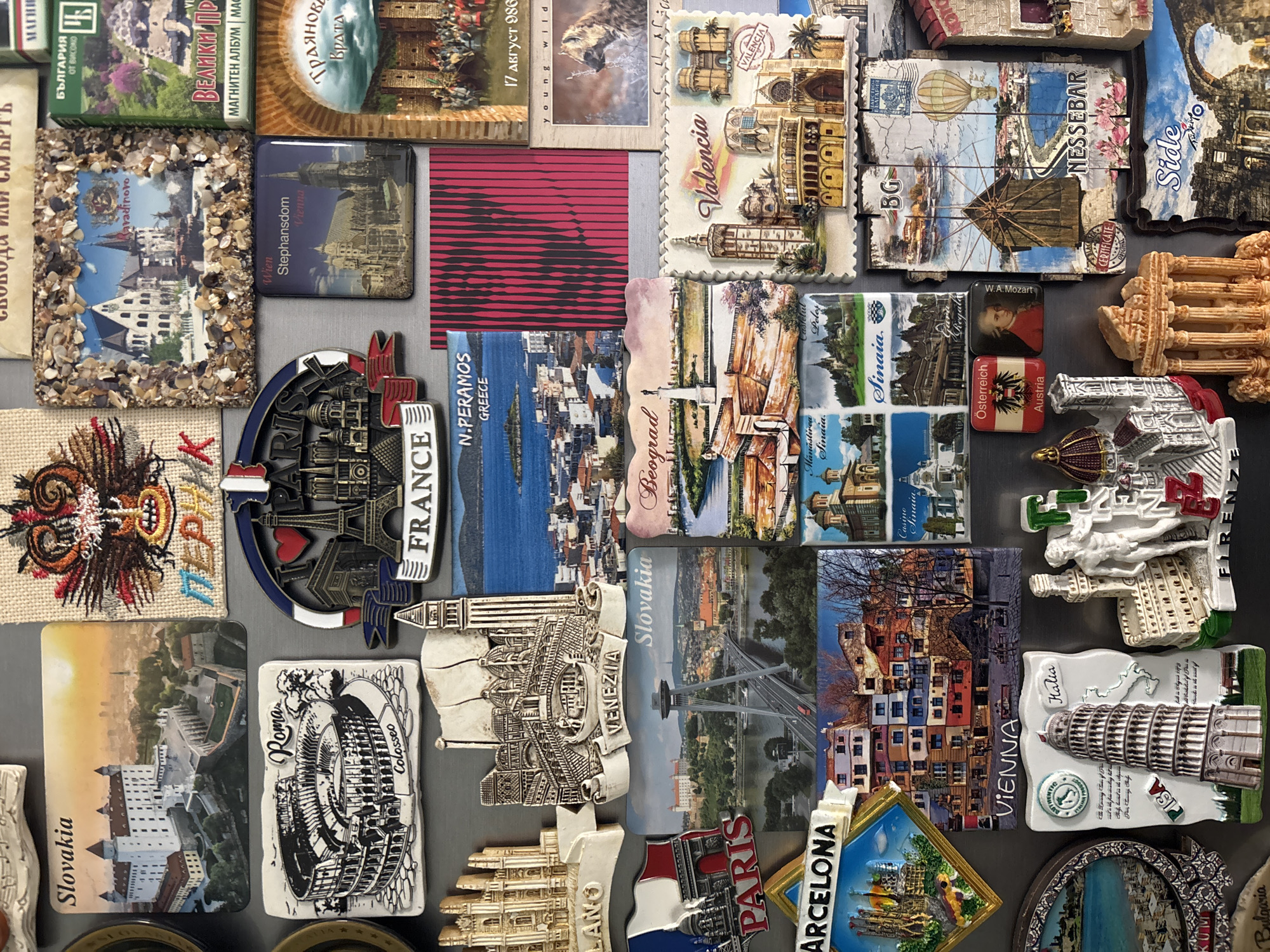 International souvenir magnet collection photographed on gray surface