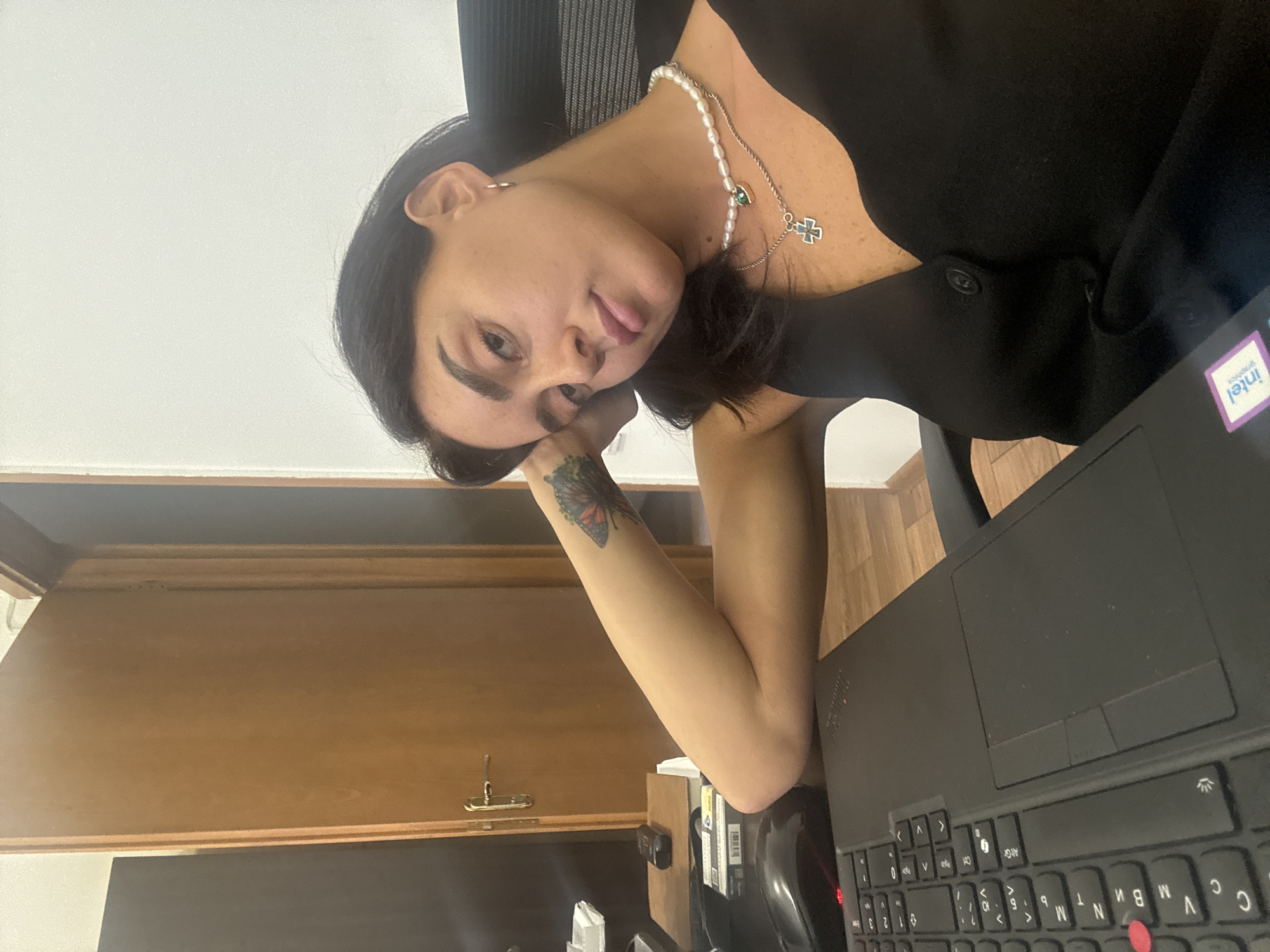 Seated in a Tbilisi office, layered necklaces, two angles