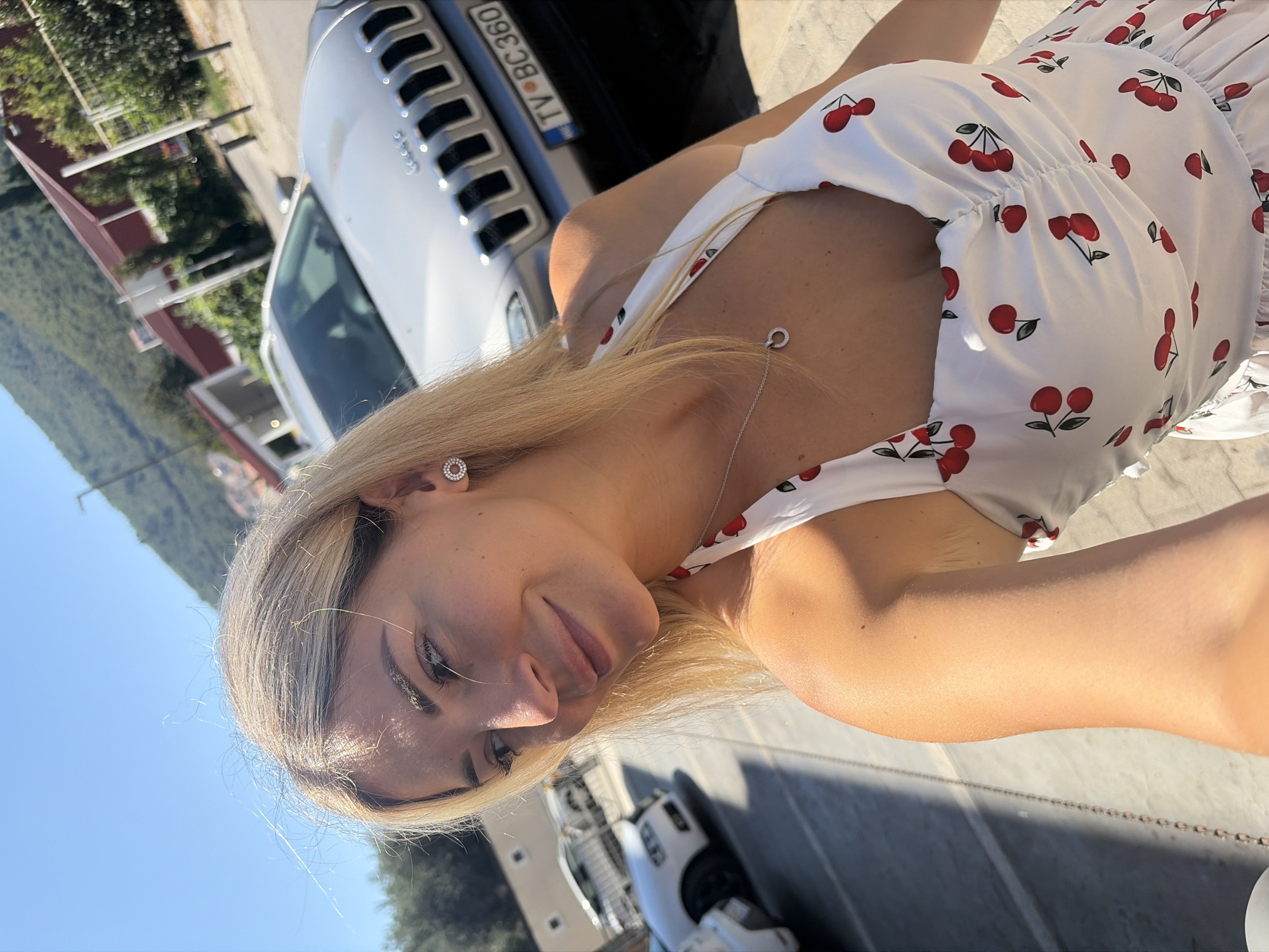 Selfie moment on a Budva street, cherry-print dress.