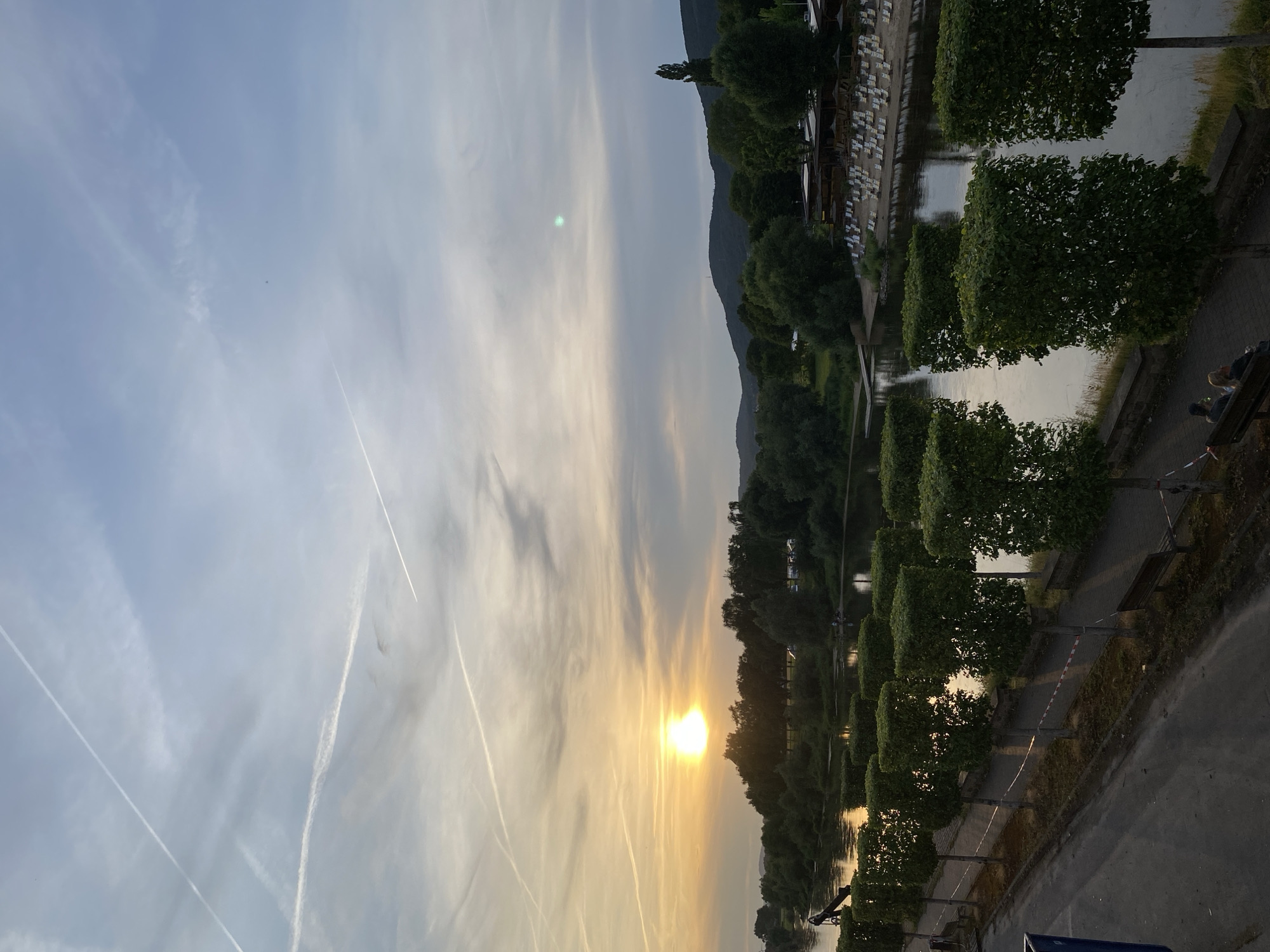 Golden sunset and contrail-filled skies over the Weser River
