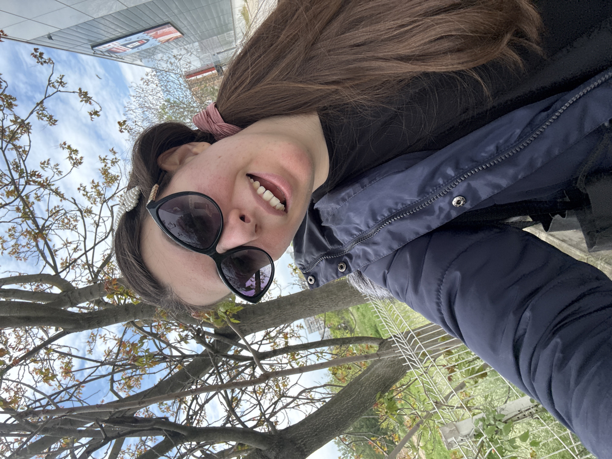 Woman takes selfie in city park amid spring blooms