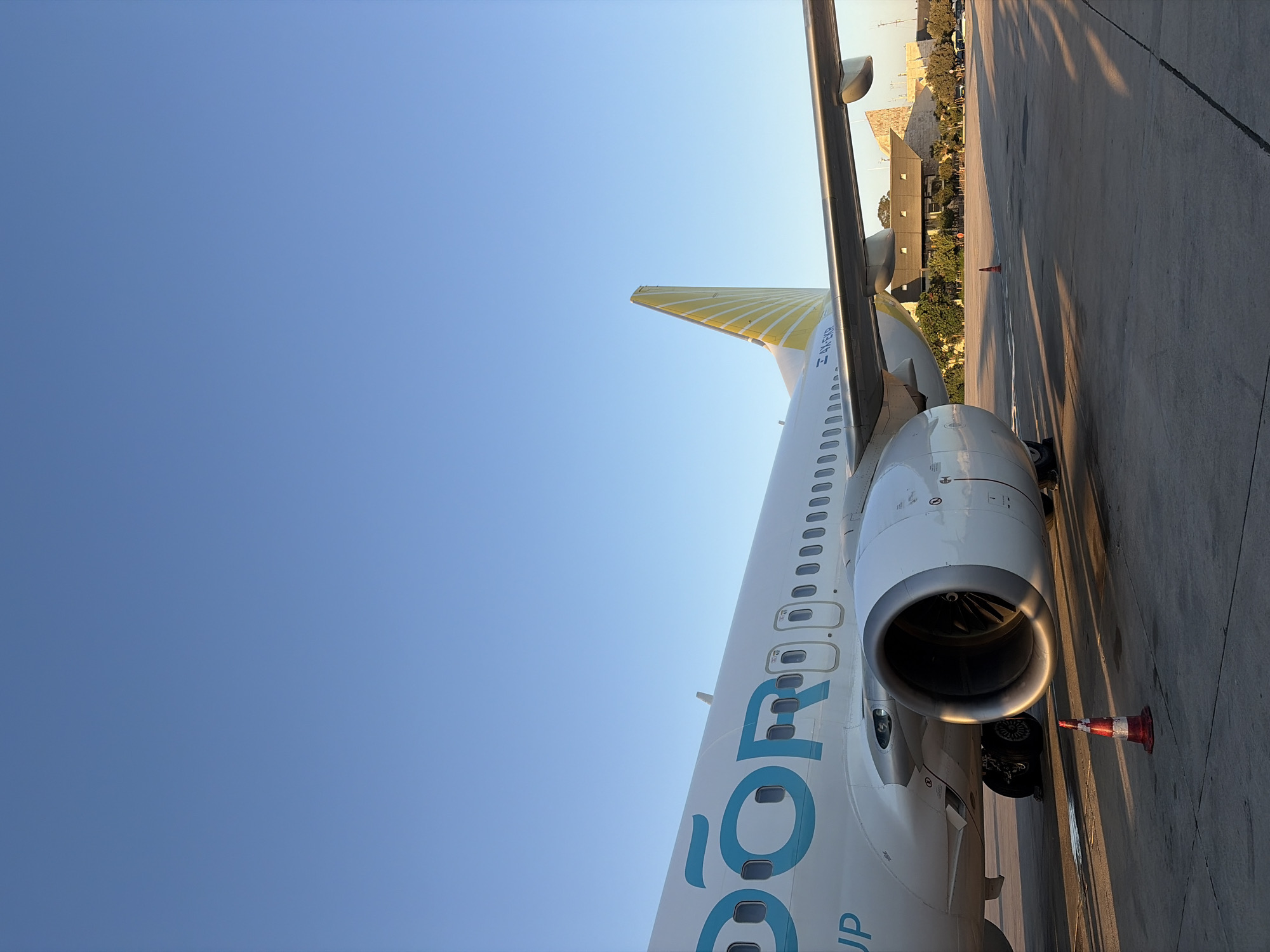 White passenger jet with yellow-striped tail, up close in Israel
