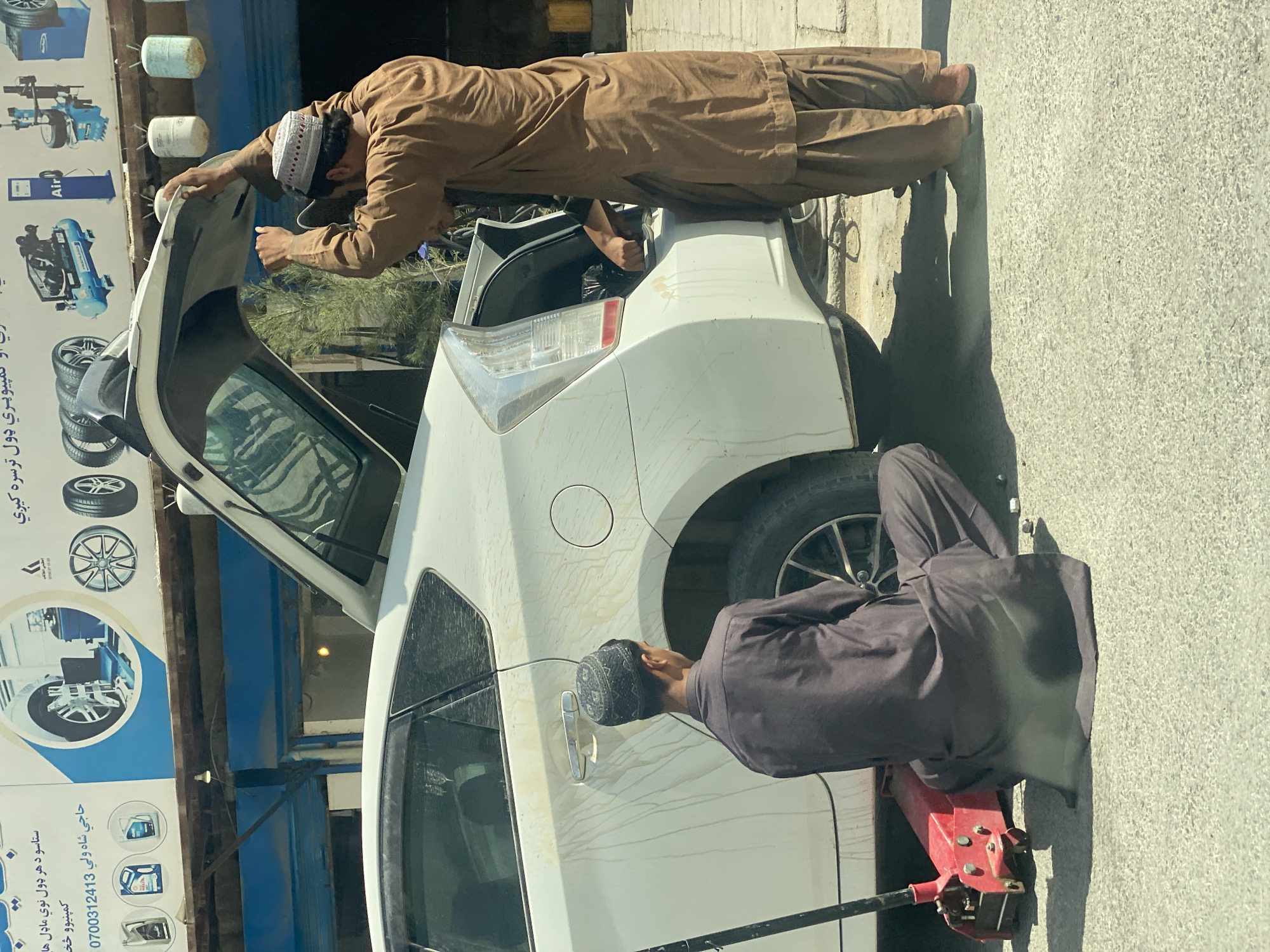 Roadside car repair underway on a Kandahar street