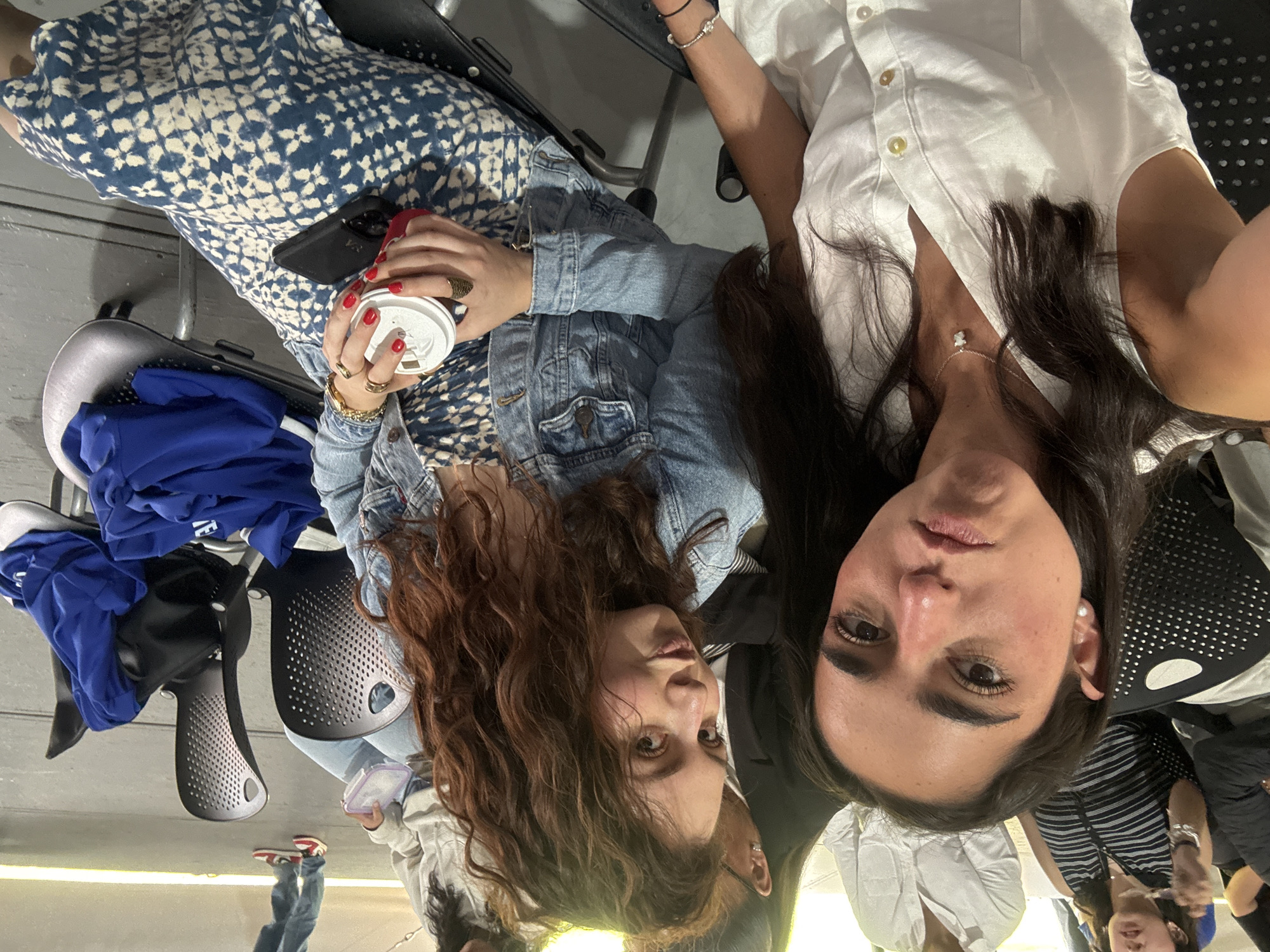 Two women photographed indoors, one in denim jacket