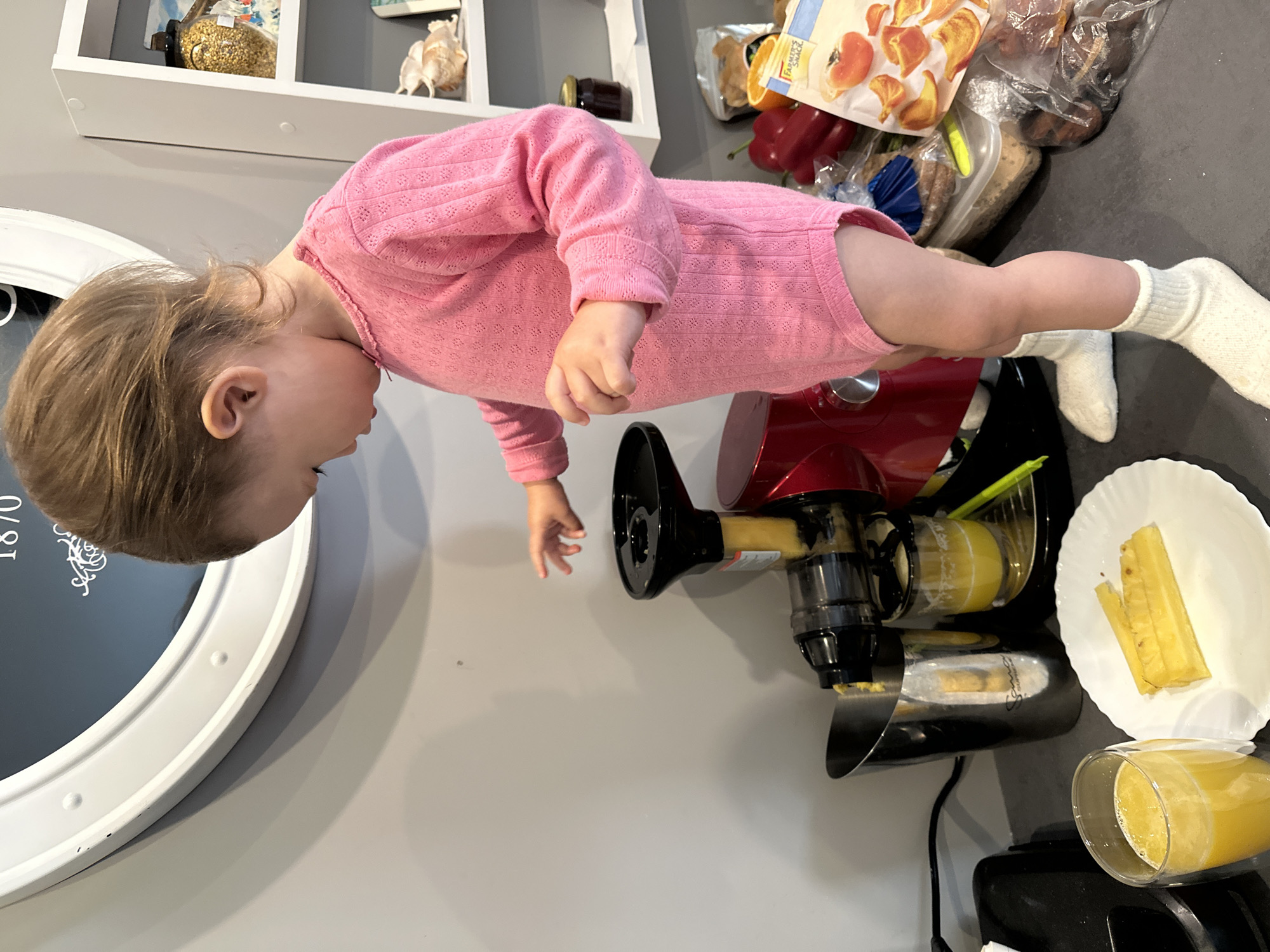 Child operates juicer in early morning kitchen scene, Wisła