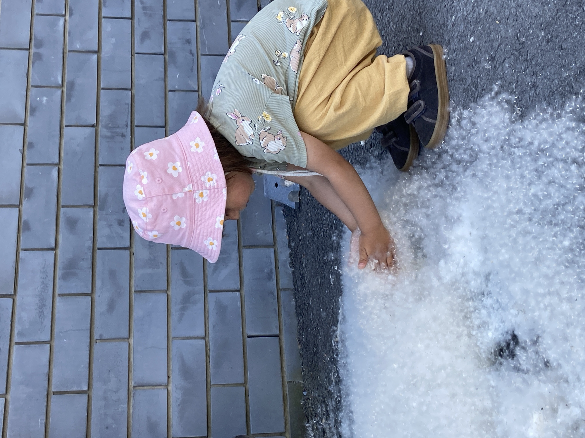 Toddler plays in cottonwood fluff covering Tyumen streets
