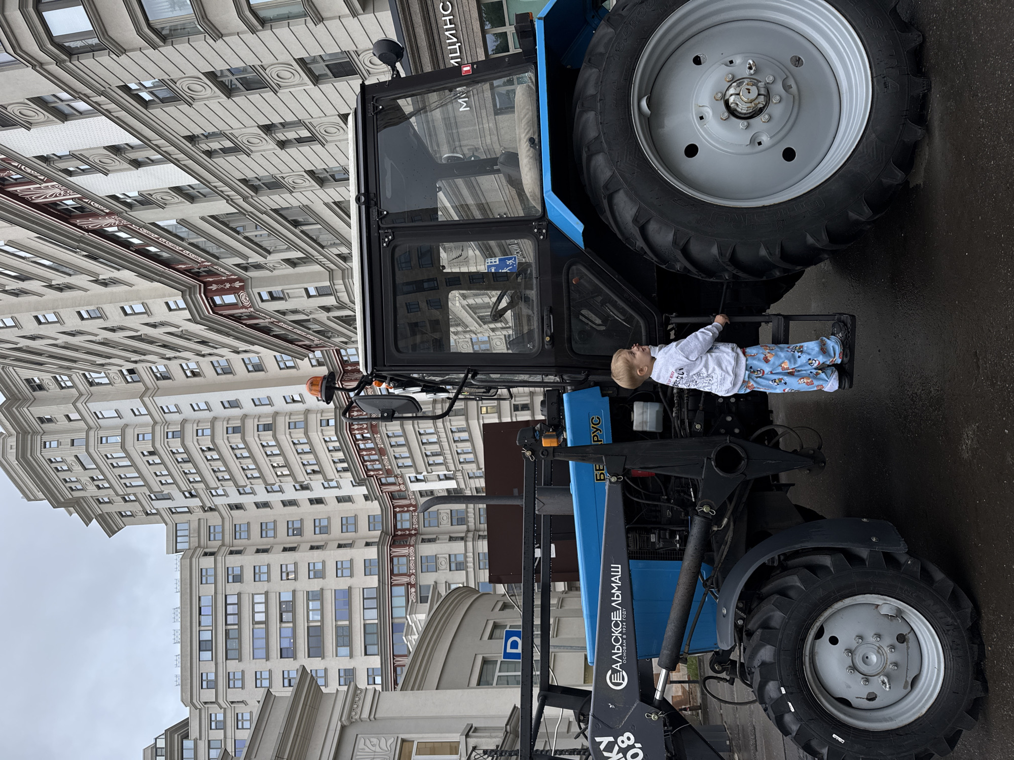Kid explores parked municipal vehicles on a Moscow street