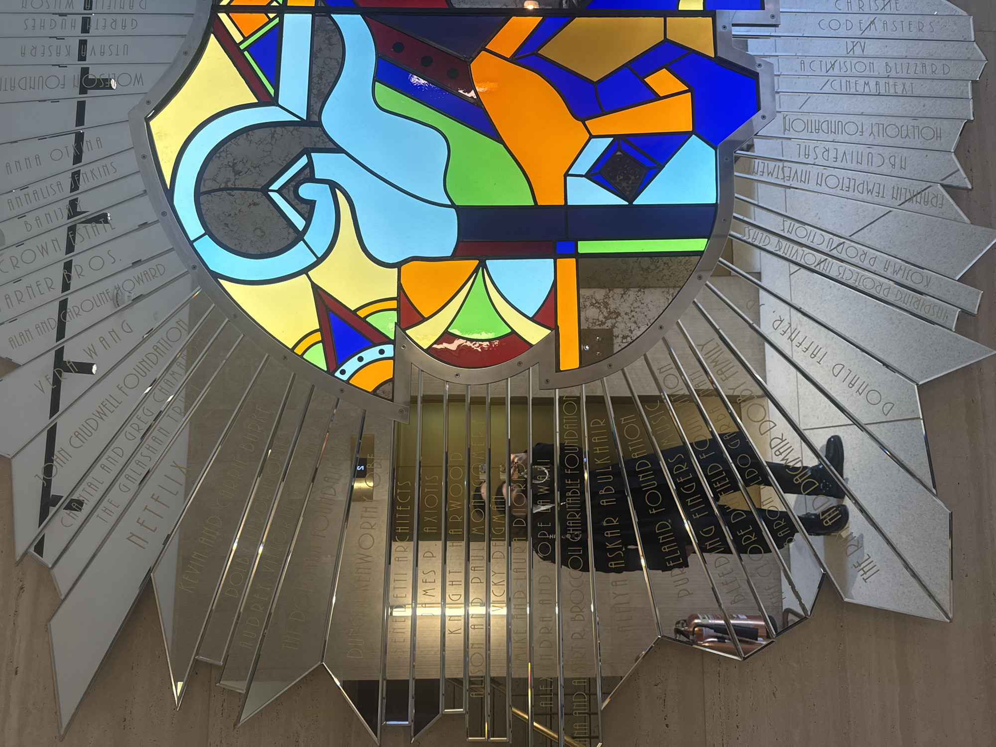 London indoor display features stained glass, visitor with beverage