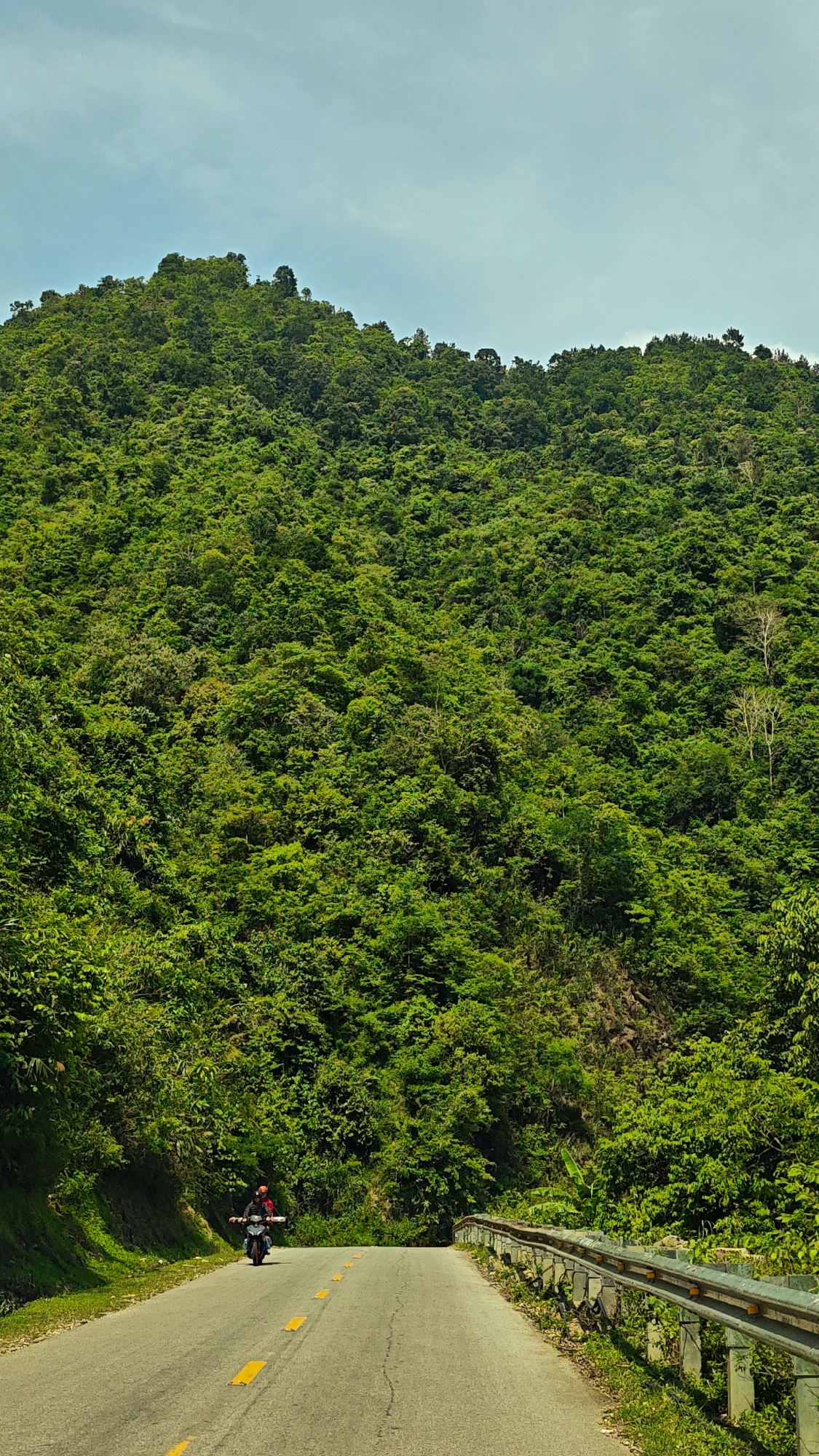 Morning traffic flows through scenic mountain road in Vietnam