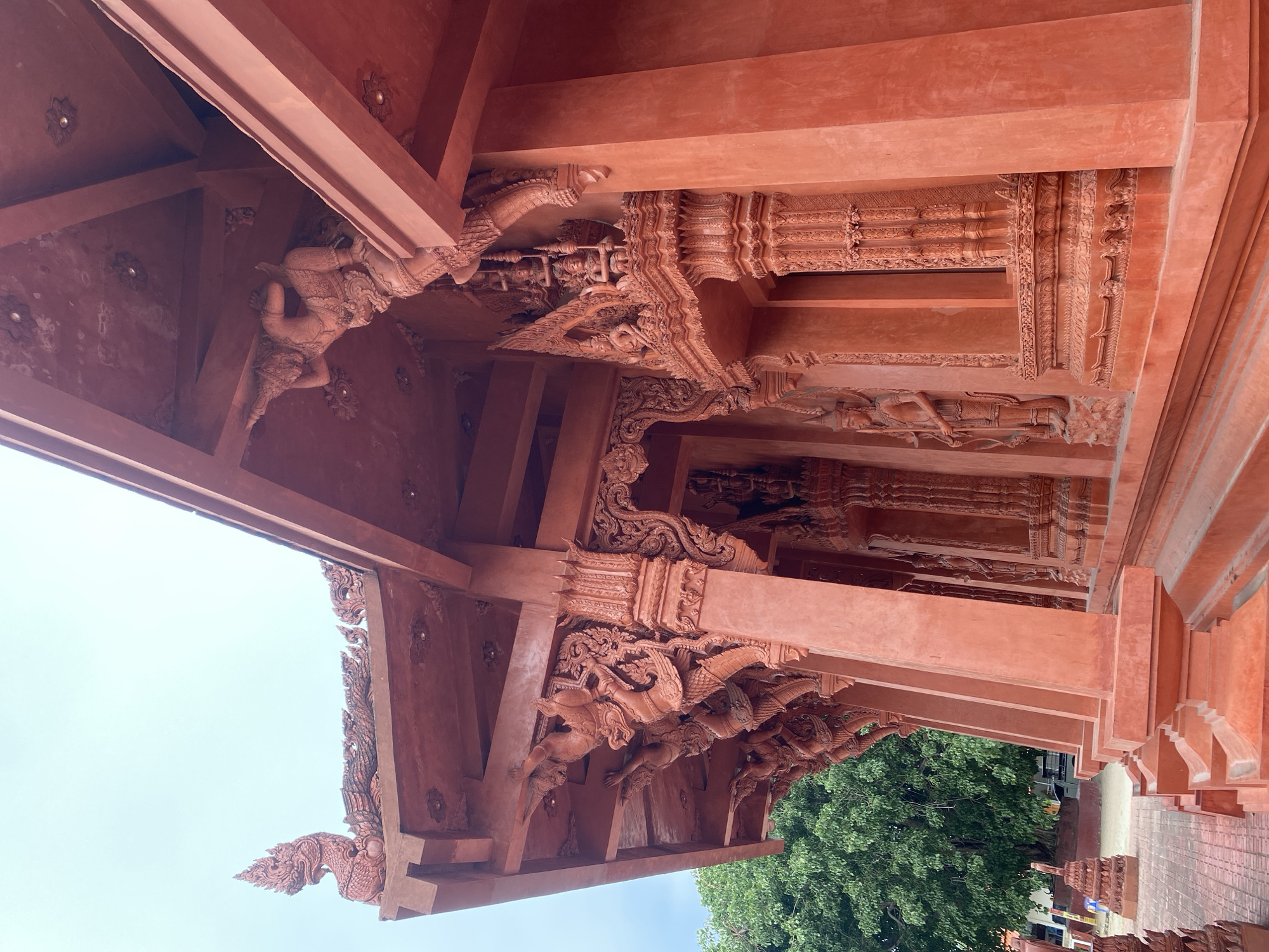 Inside a richly carved red temple complex in Baan Hua Thanon
