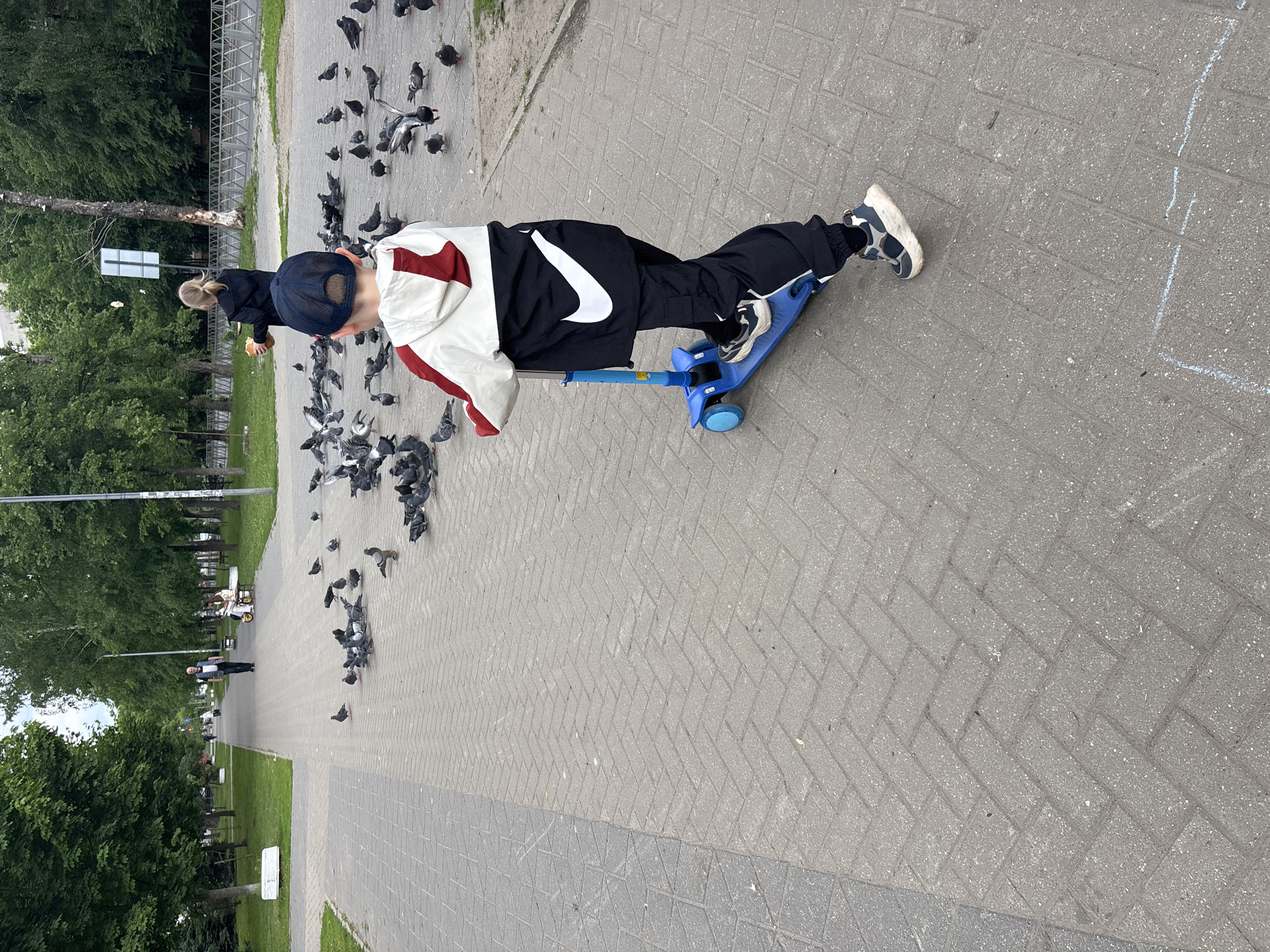 Child with Patriots cap plays with scooter in Russian park