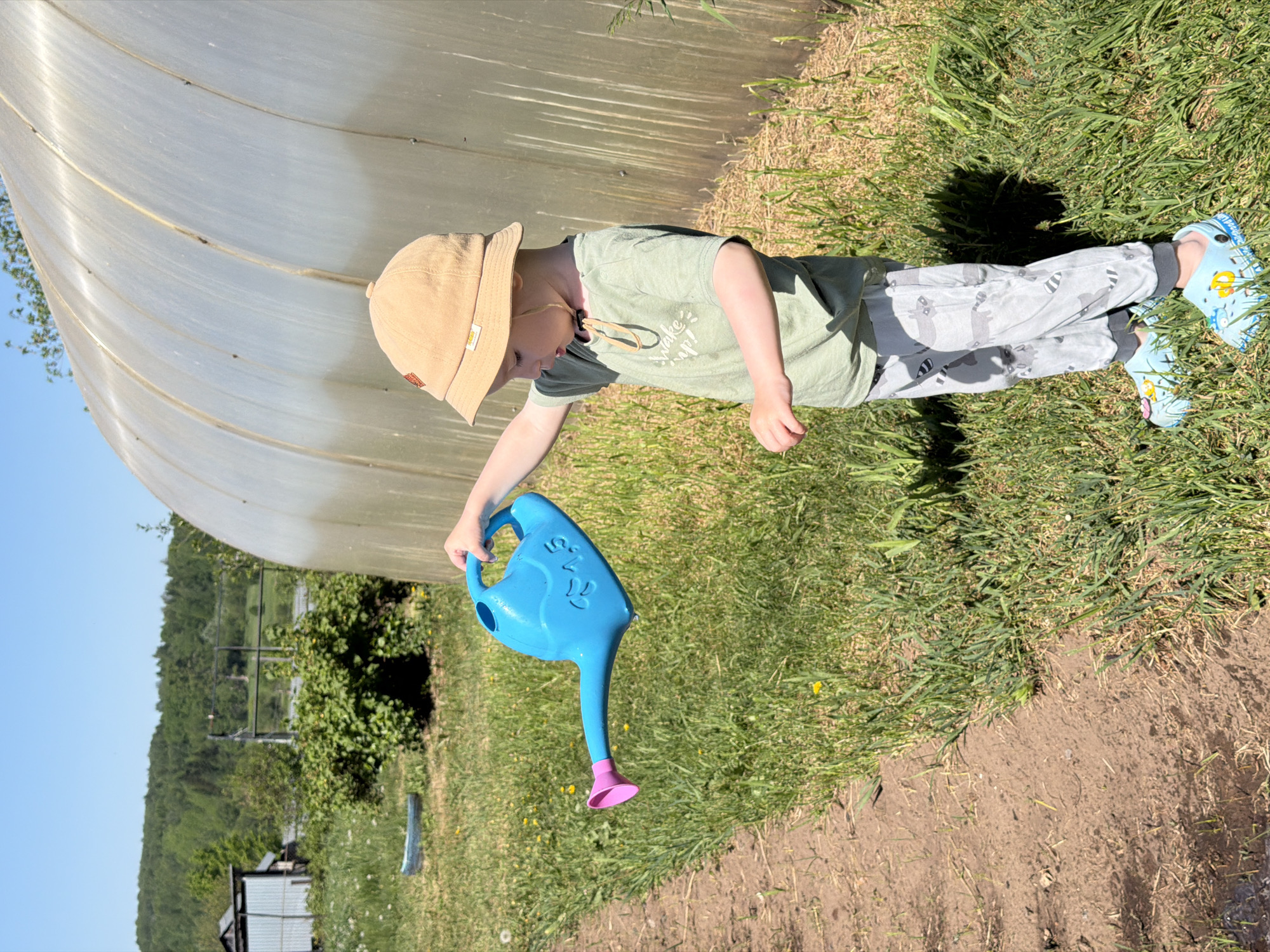 Child gardens and plays with water in Russian village