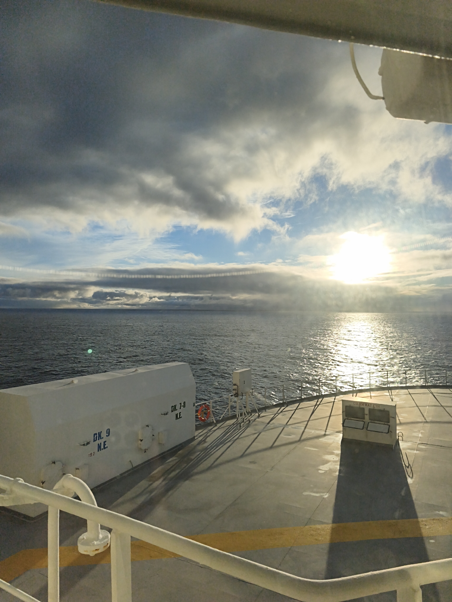 Storm clouds and sun divide the sky over open water