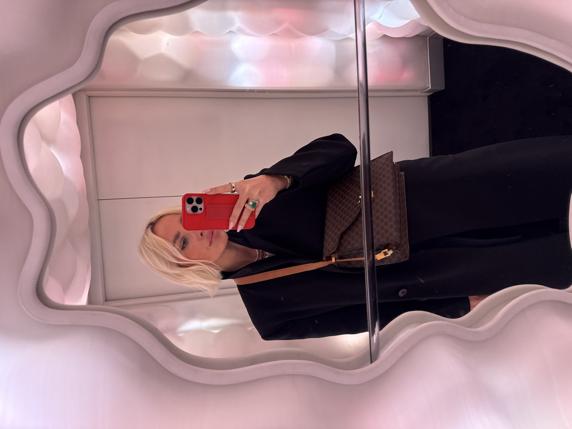 Person takes mirror selfie with red phone