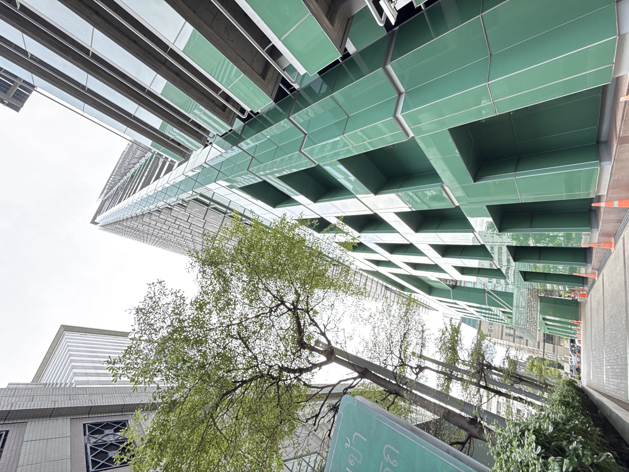 Street-level Bangkok: skywalks, delivery riders, and modern towers