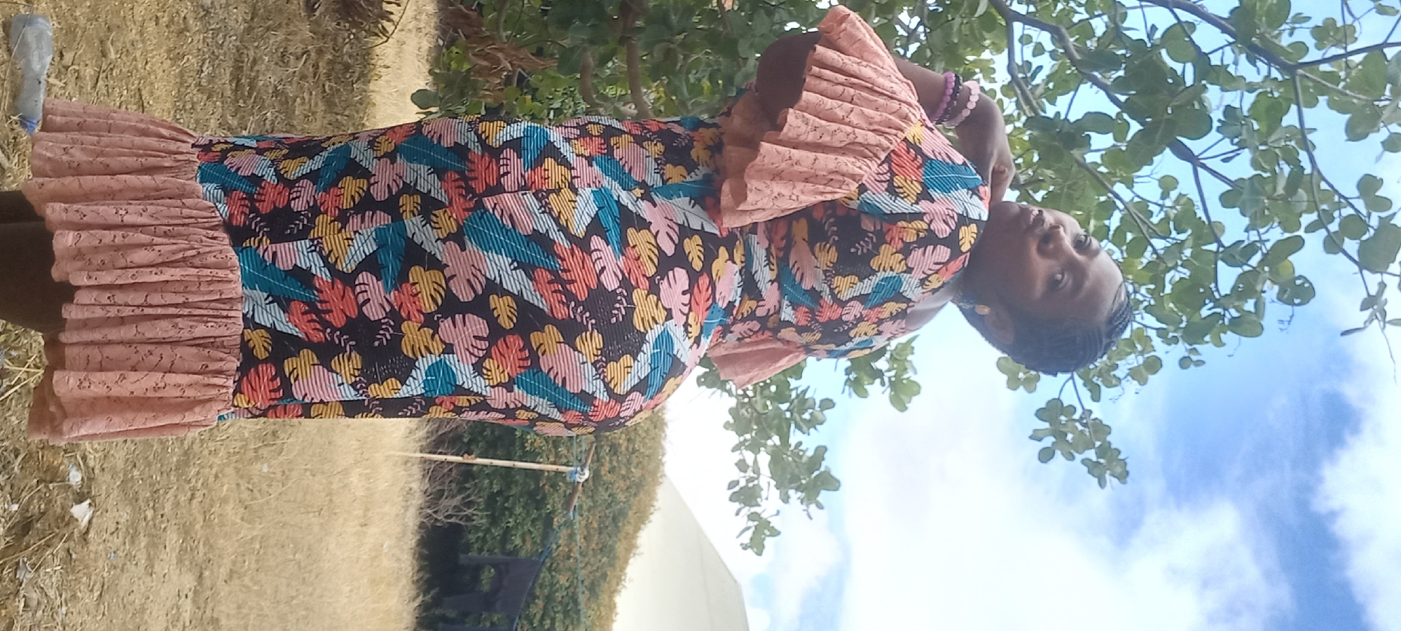 Outdoor fashion shoot in Jos with floral dress and rustic backdrop