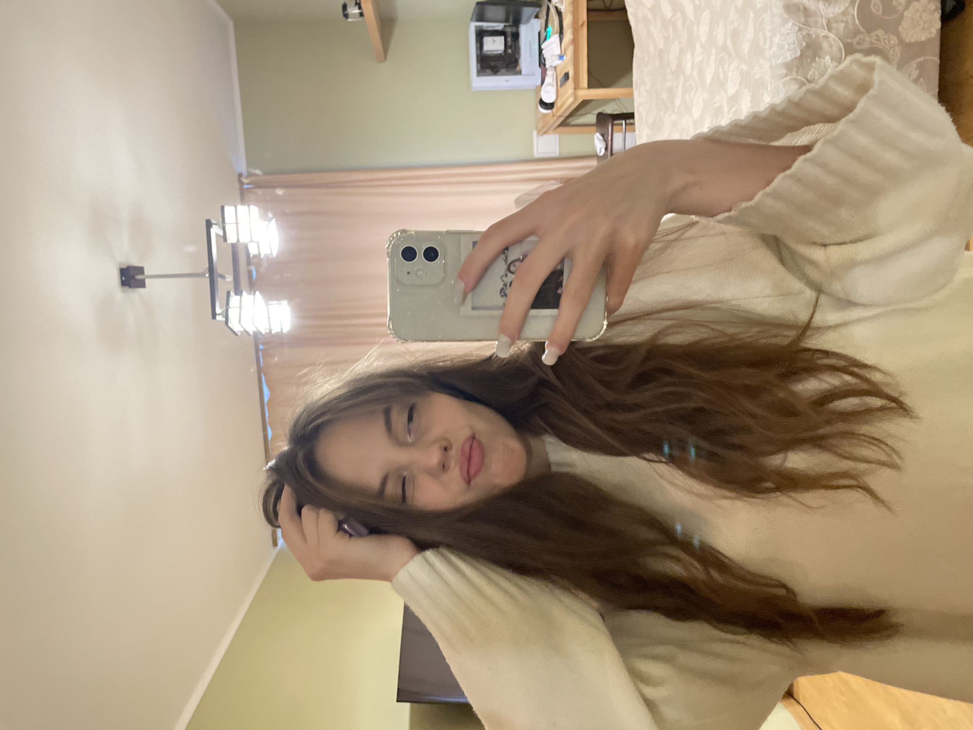 Woman takes selfies while styling hair in Ufa residence