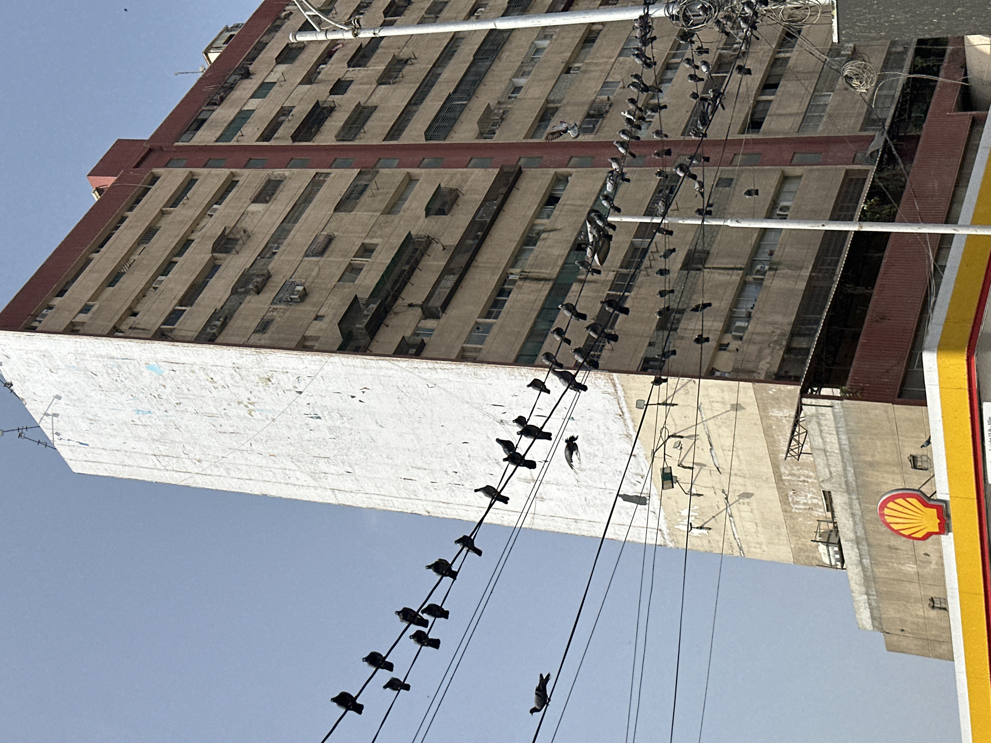 Aged apartment block and utility wires on a Karachi street.