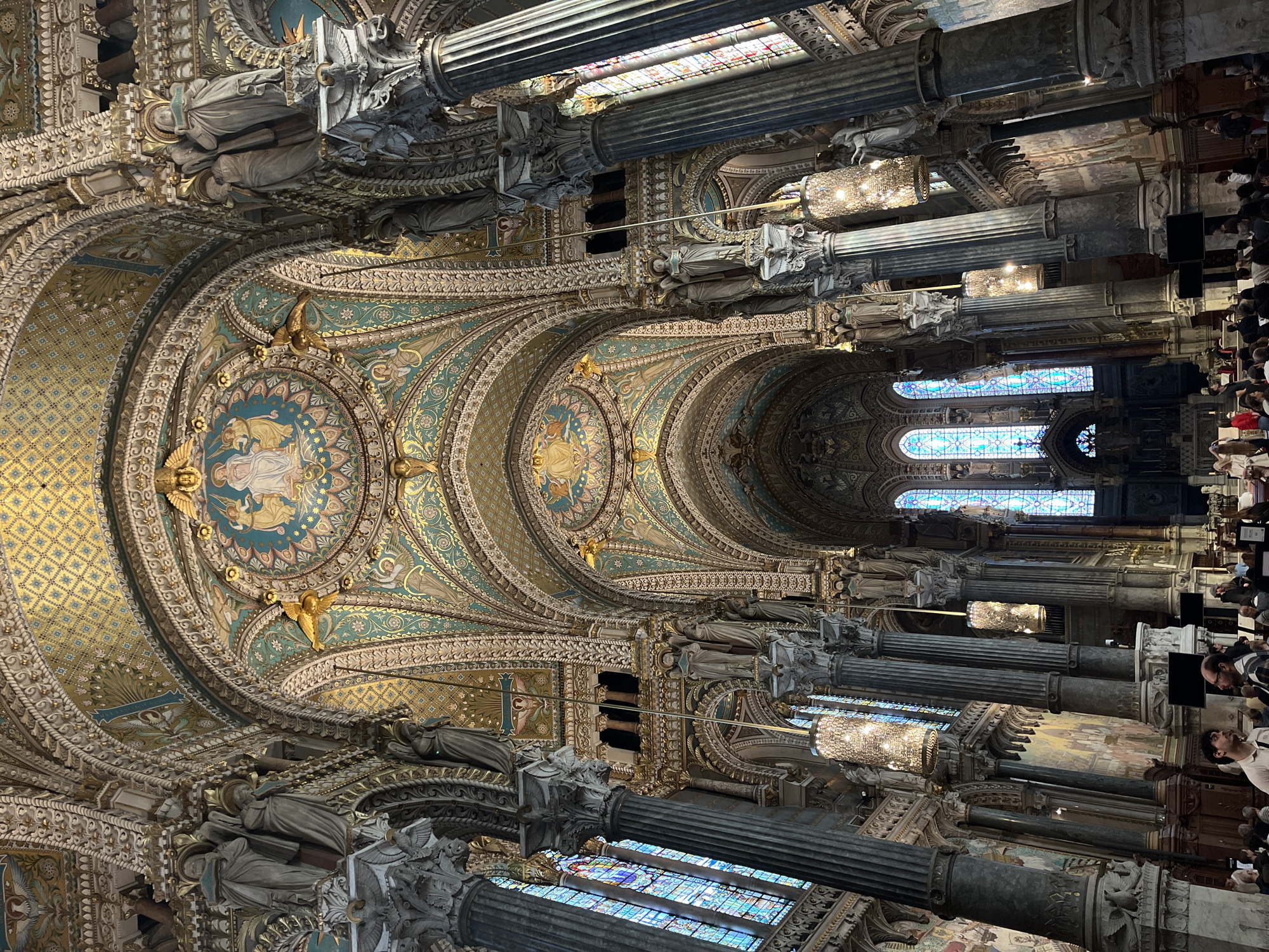 Visitor documents ornate interiors at Lyon's Notre-Dame de Fourvière basilica
