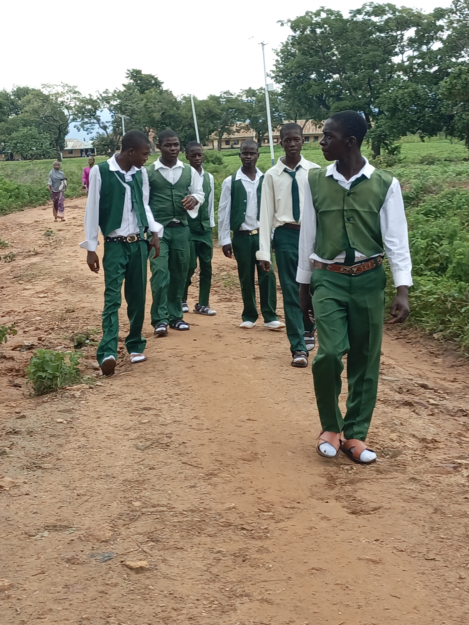 Students head to school along a dirt road in Akwanga, Nigeria