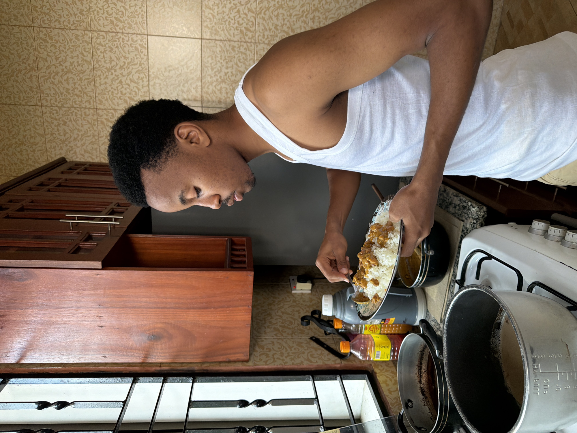Plating rice and curry in a Dar es Salaam kitchen