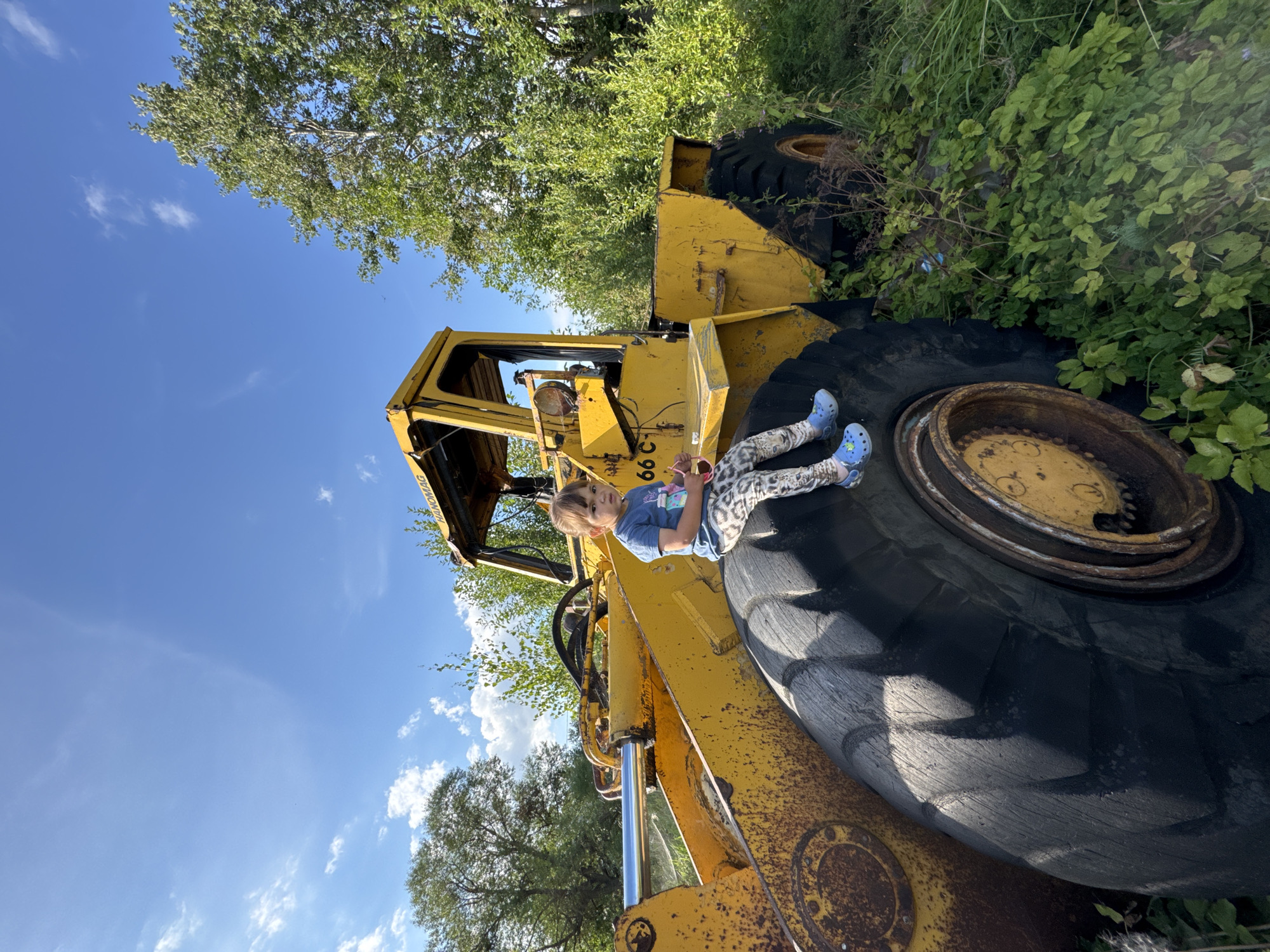 Kid climbs abandoned yellow loader in rural Innolovo, Russia