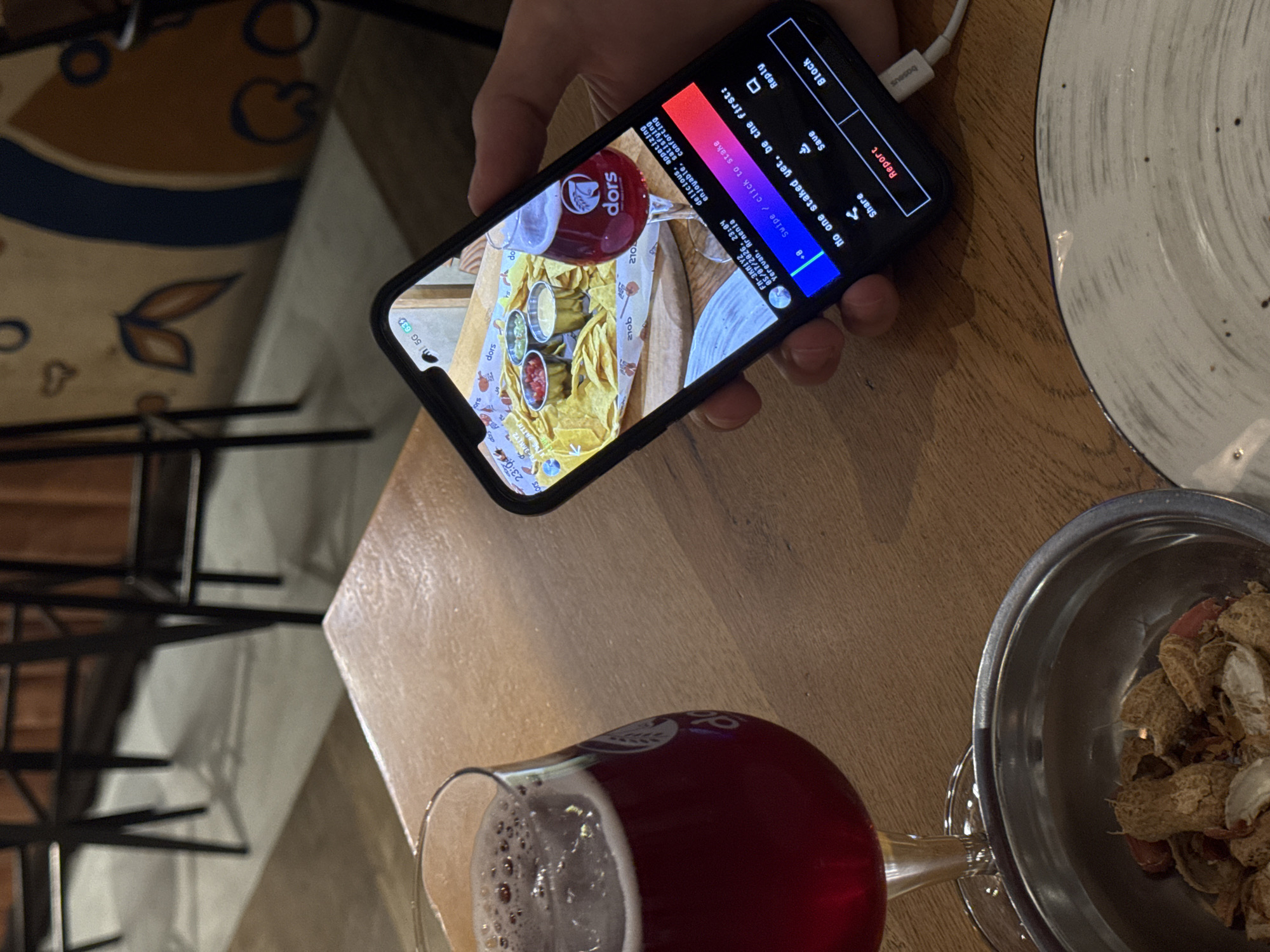 Diner photographs nachos and beer meal in Yerevan restaurant
