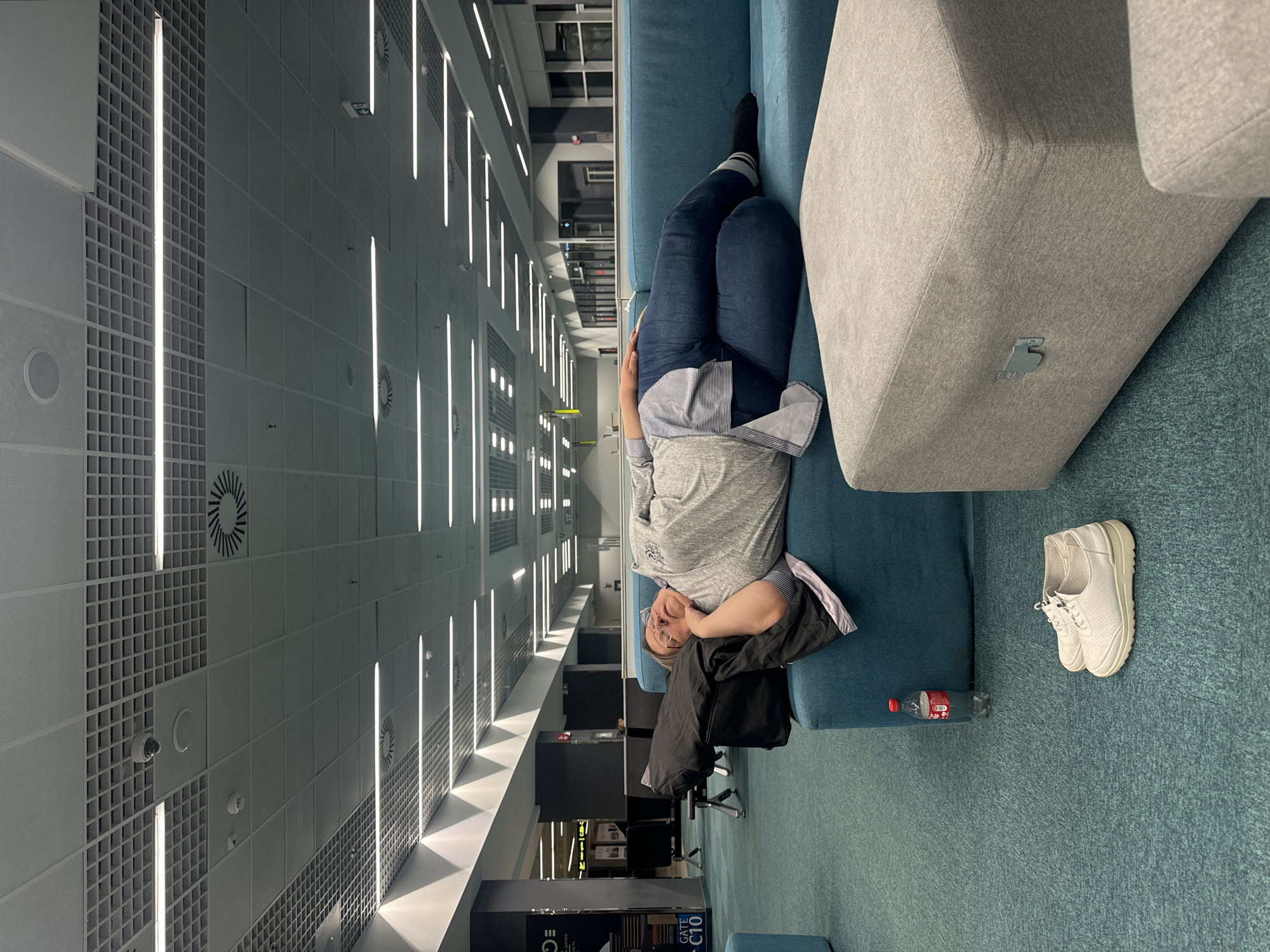 Person rests on sofa in modern building