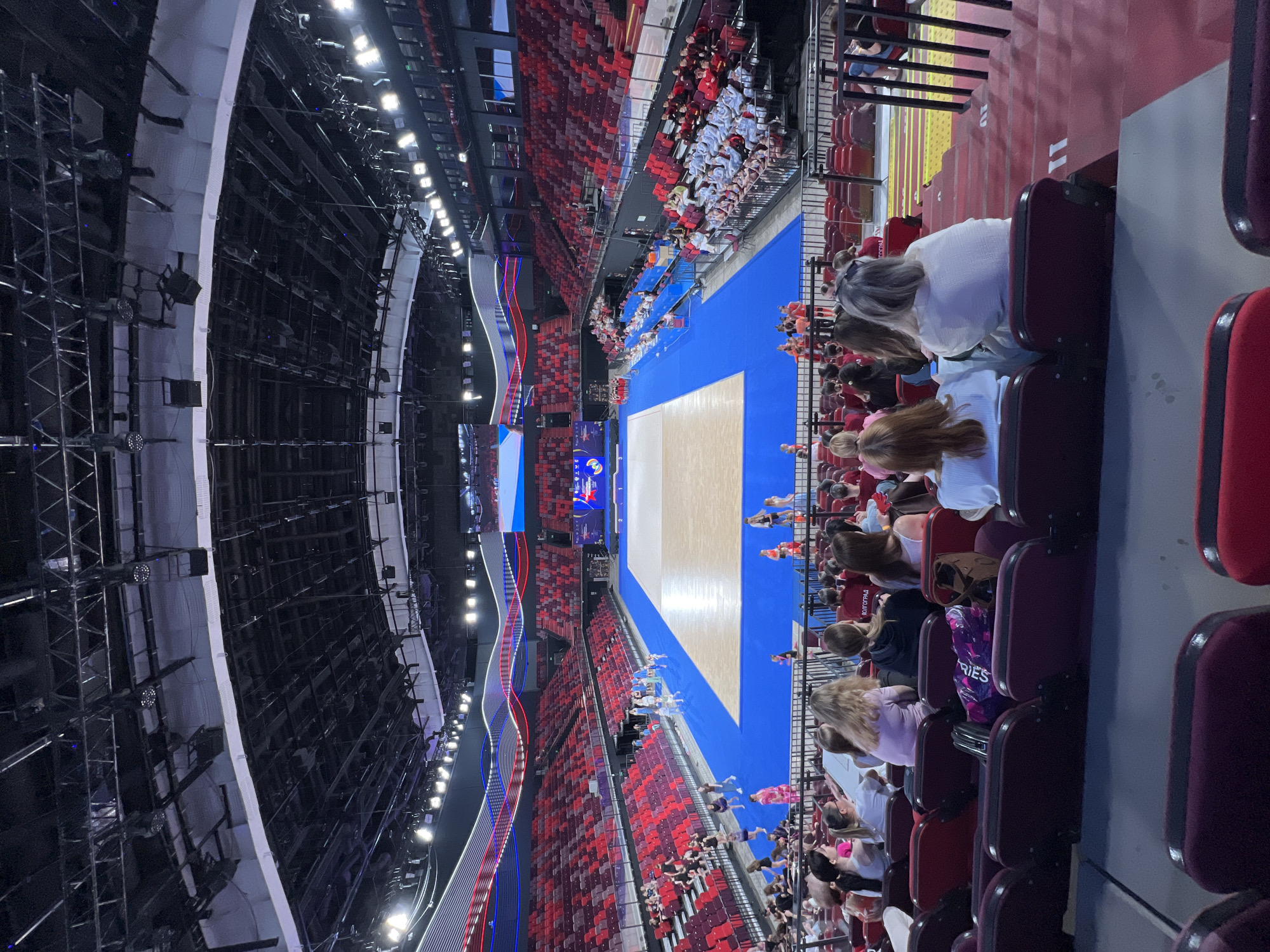 Young gymnasts perform synchronized routine in indoor arena