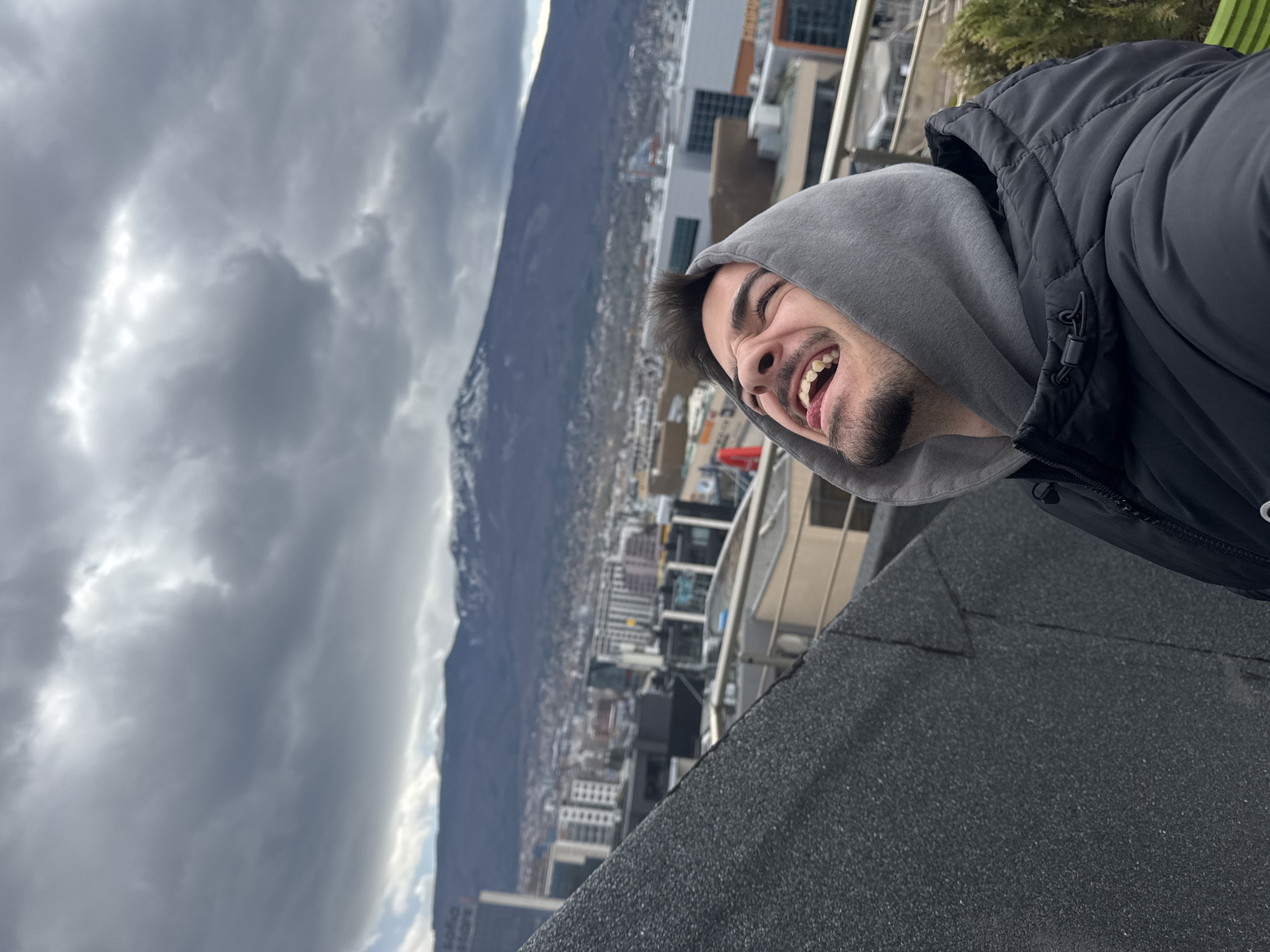 Man takes rooftop selfies overlooking Sofia cityscape