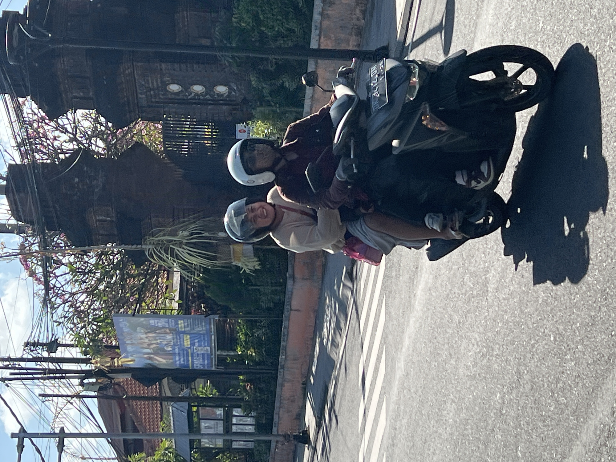 Morning scooter traffic and a stained-glass shopfront in Denpasar