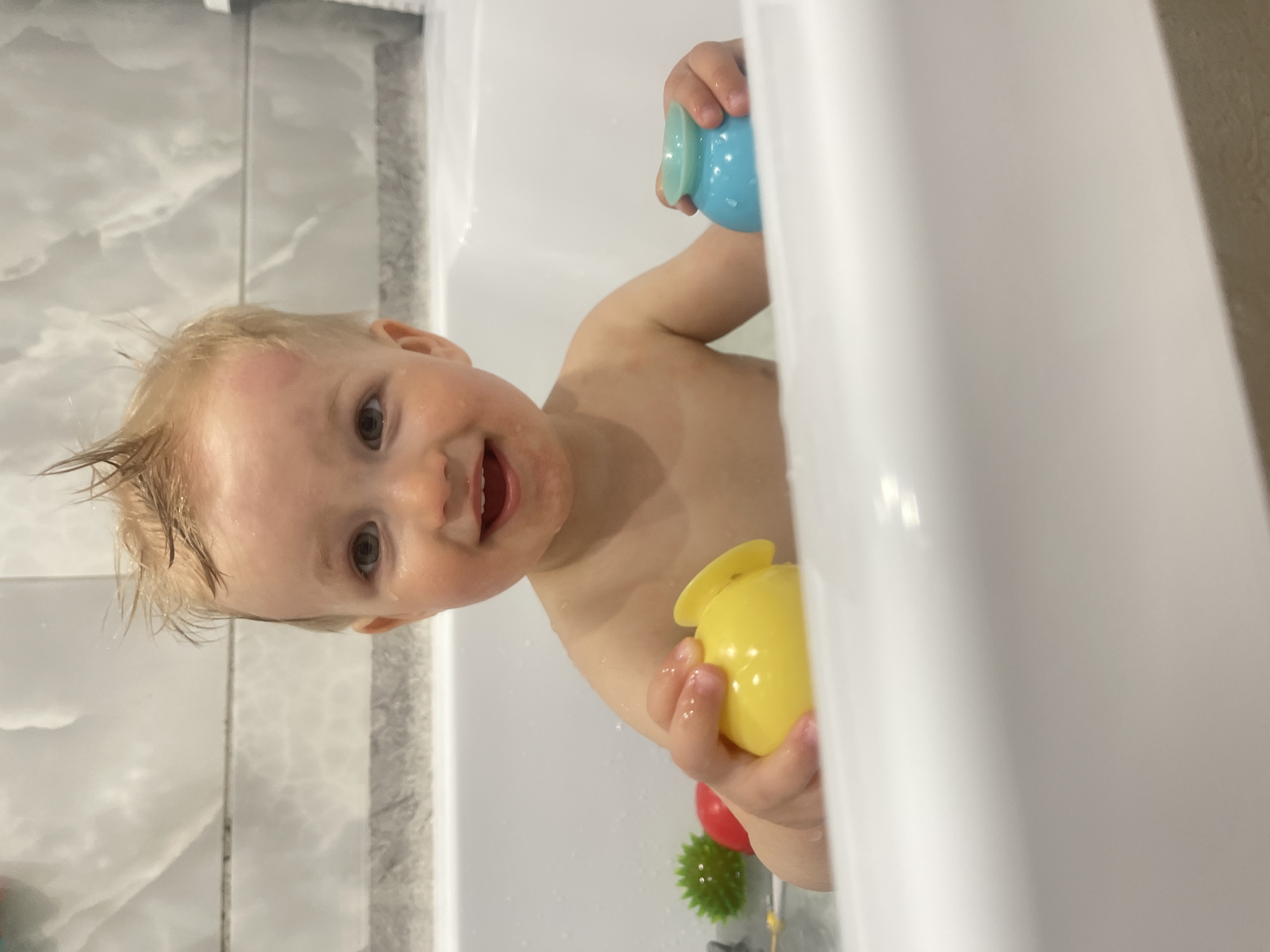 Child enjoys bath time with toys in Izhevsk home