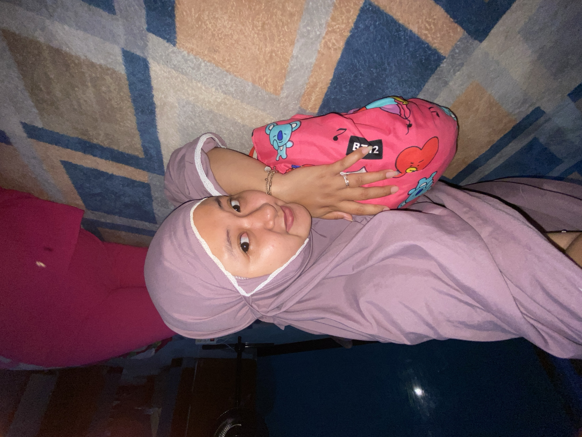 Young woman in hijab photographed reclining indoors in Gelam