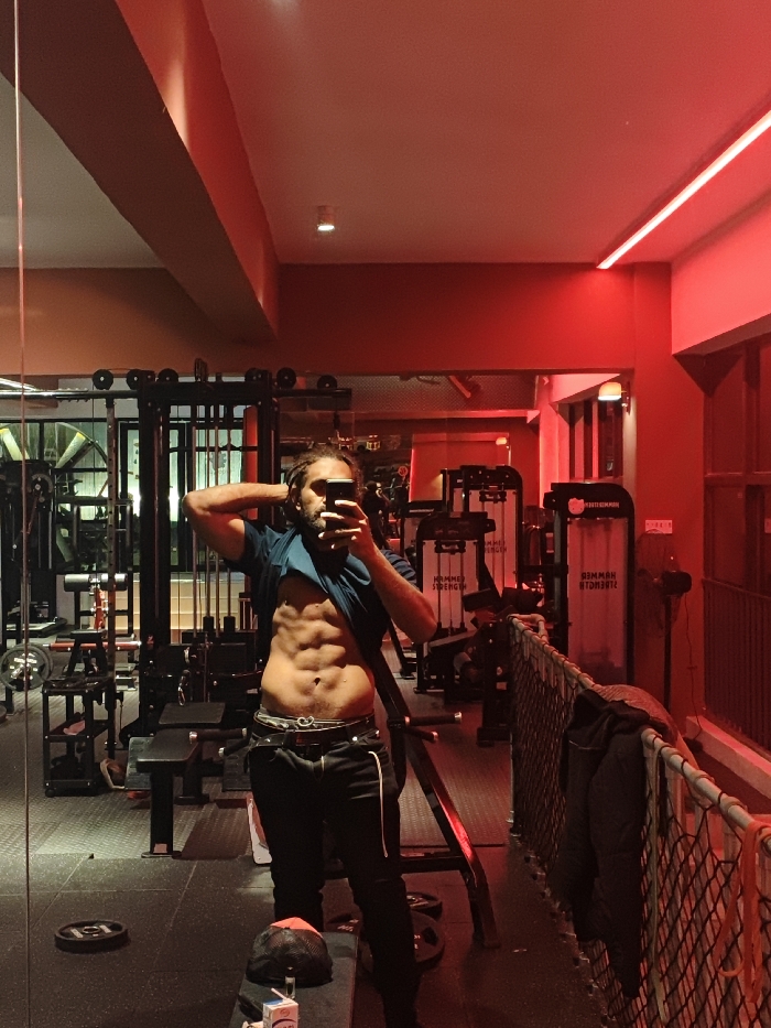 Man completes workout routine at Chongqing gym, cats rest nearby