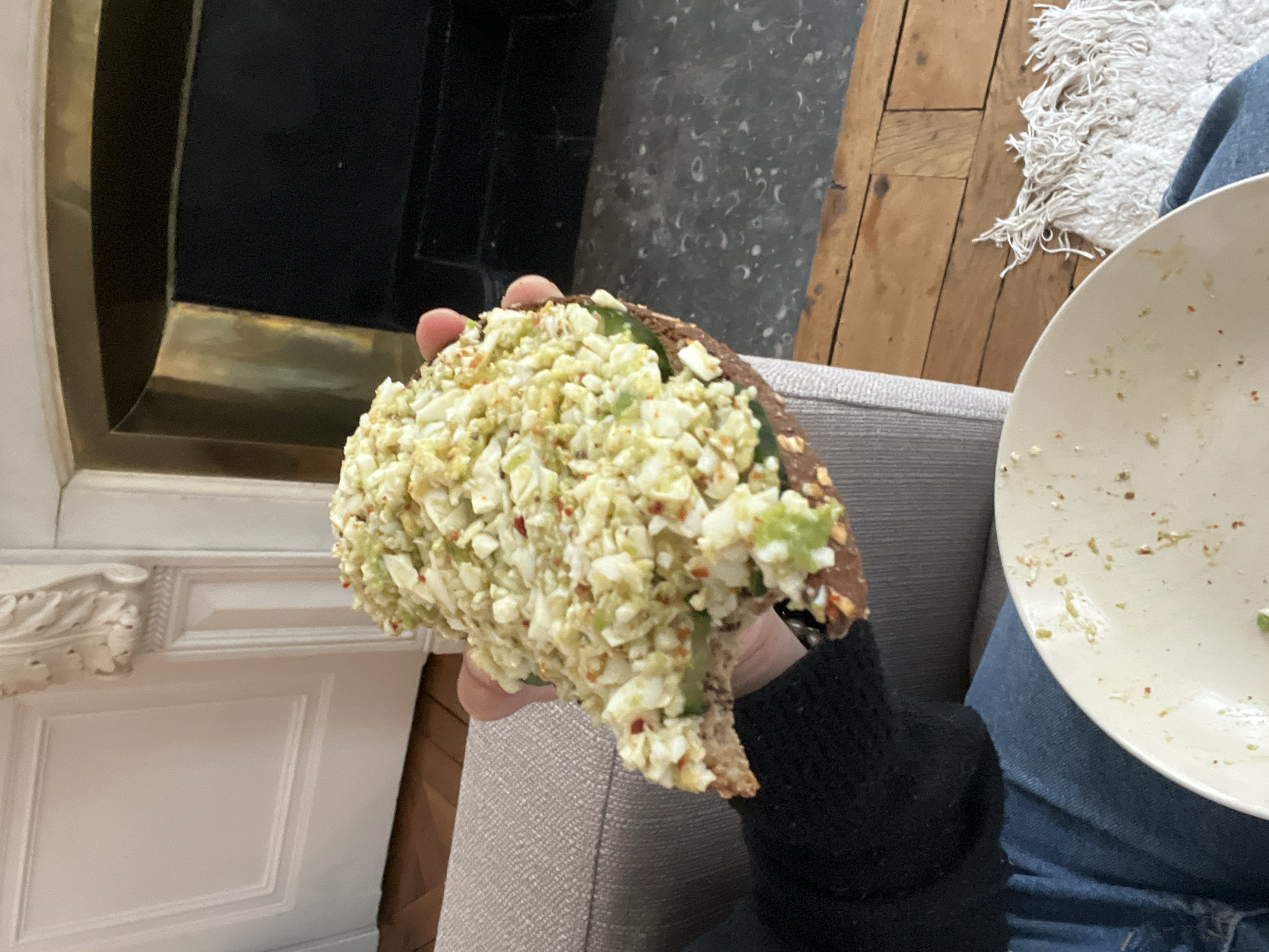 Person holds egg salad sandwich in Lyon, France