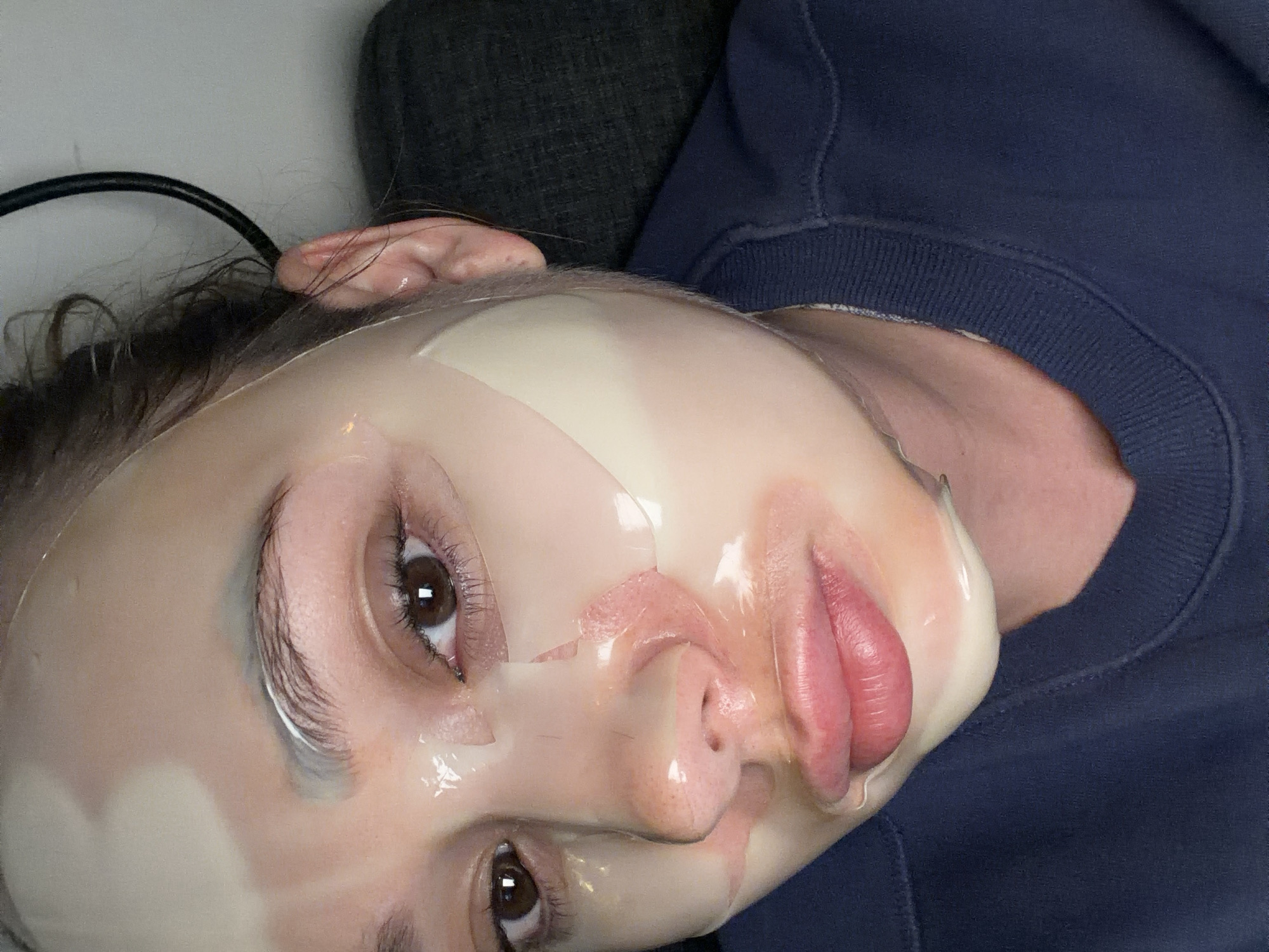 Person wearing facial sheet mask photographed in Ramat Gan