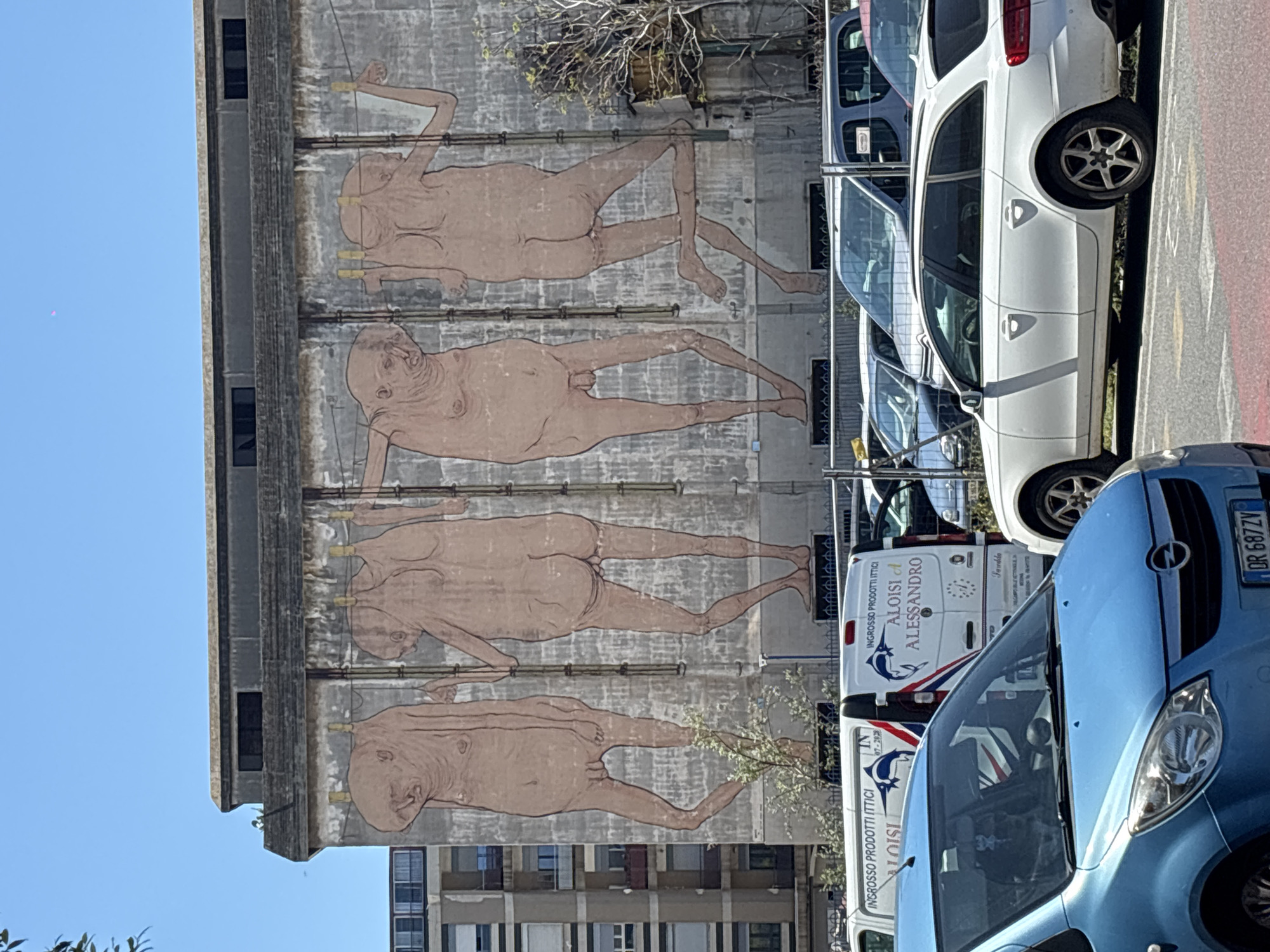 Brutalist building with nude figure mural observed in Messina