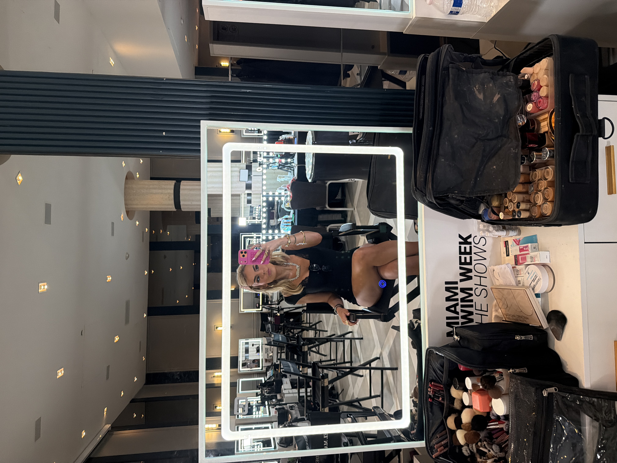 Woman takes selfies at Miami Swim Week makeup station