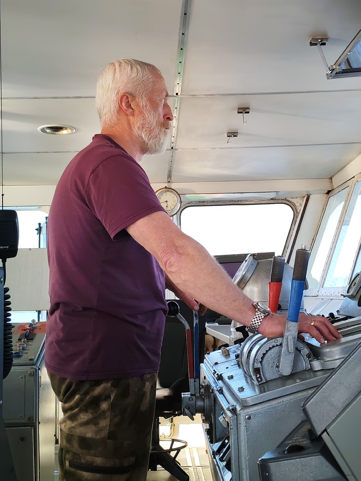 Elderly man operates vessel controls in Pochinok, Russia
