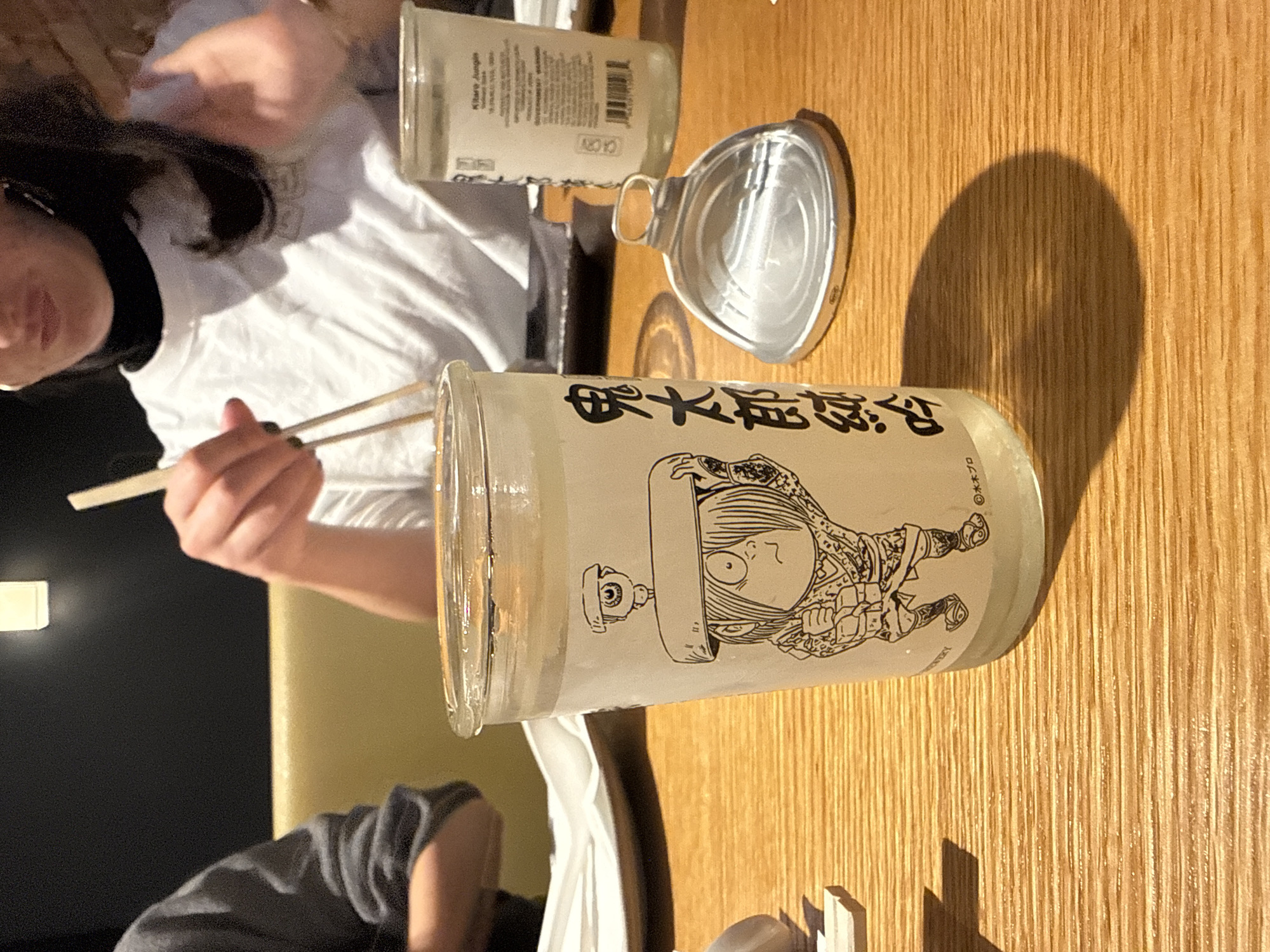 Person enjoys ramen dinner at wooden table in New York