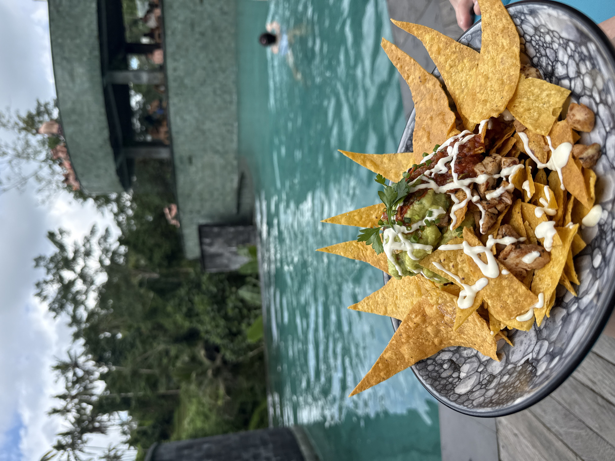 Tourist documents poolside meal at Tegallalang resort, Indonesia
