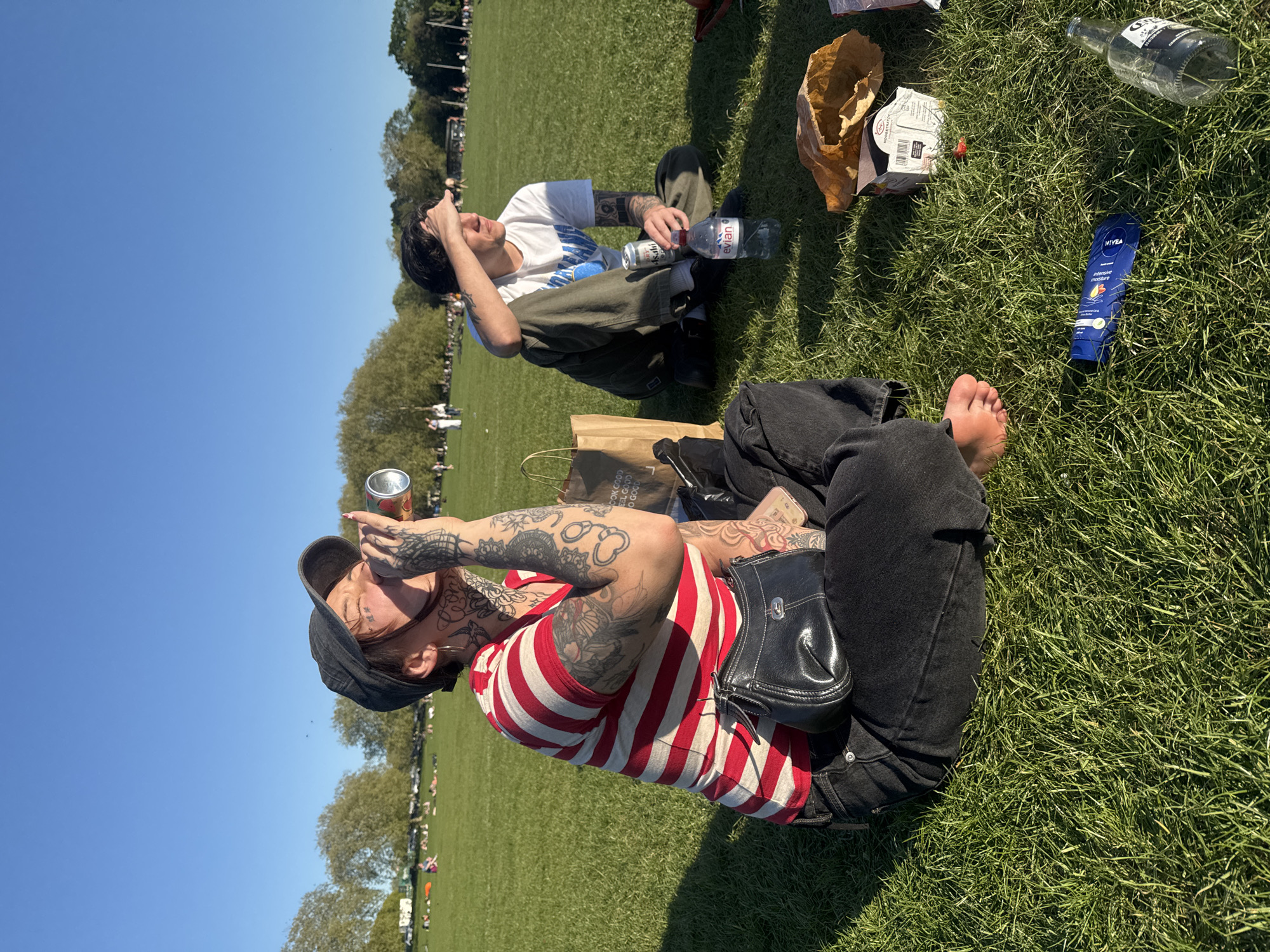 Two people enjoy sunny afternoon in London park