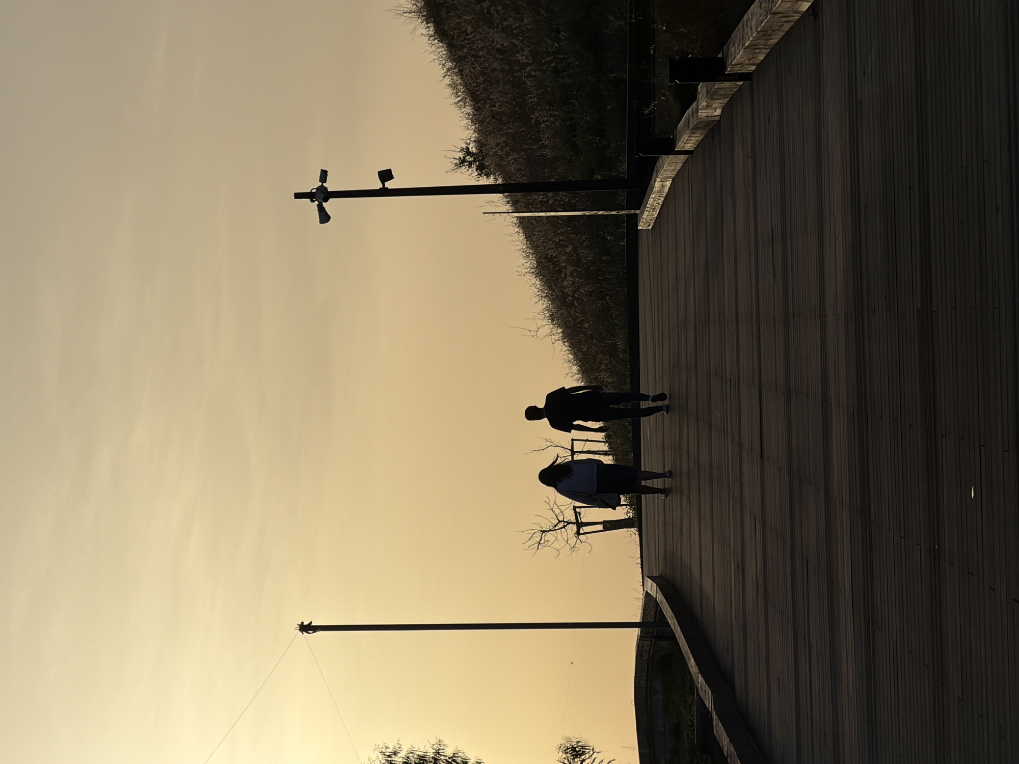 Couple walks Rishon LeZion boardwalk during golden hour