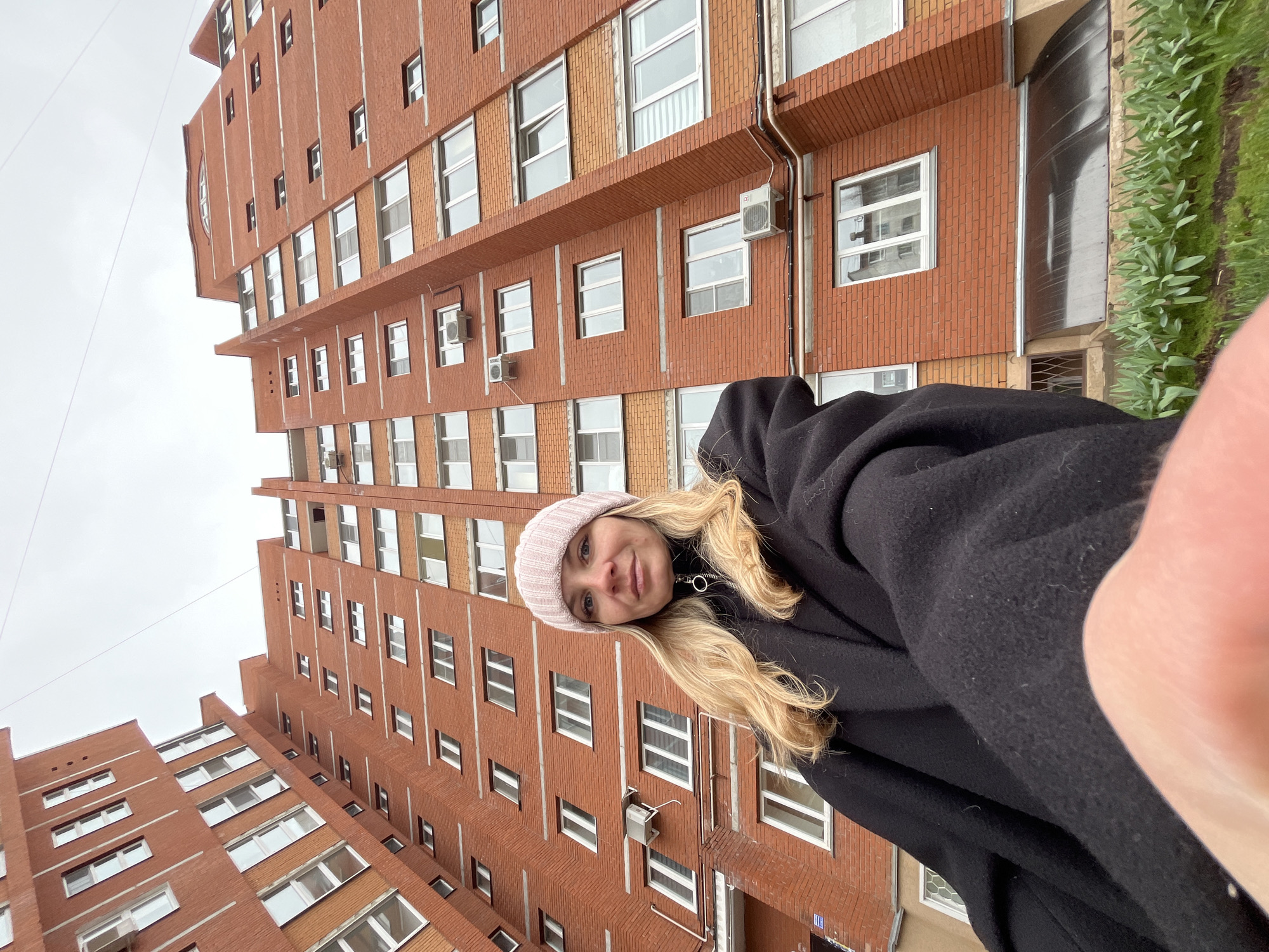 Woman takes selfies outside residential building in Chaikovsky