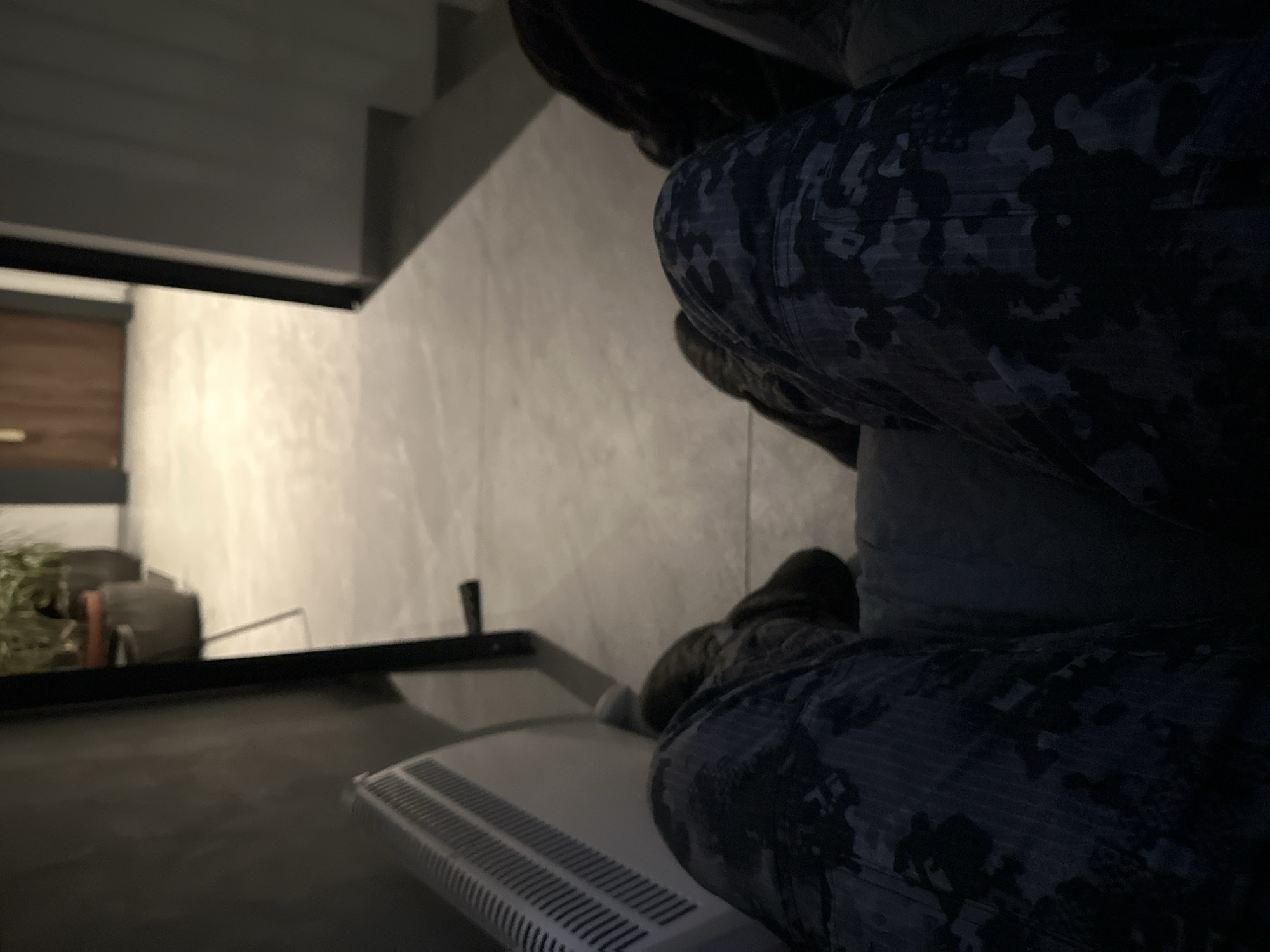Person in camouflage sits on radiator in Sofia interior