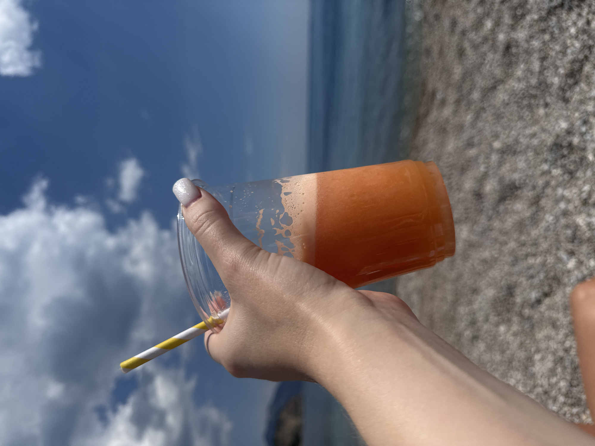 Beachgoers enjoy colorful drinks during sunny afternoon in Montenegro